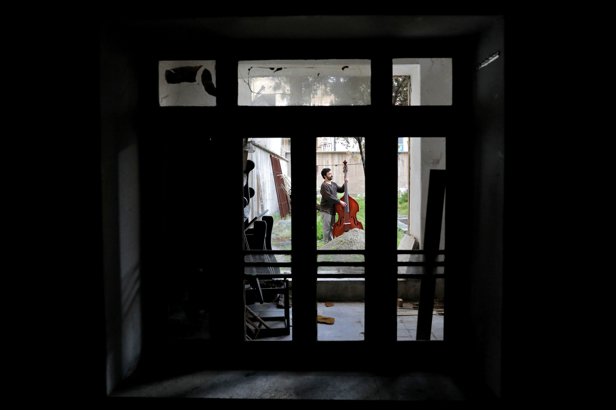 Arif Mirbaghi plays a double bass in his backyard during mandatory self-isolation to prevent the spread of the coronavirus in Tehran, Iran, on April 5, 2020. (AP Photo/Ebrahim Noroozi)