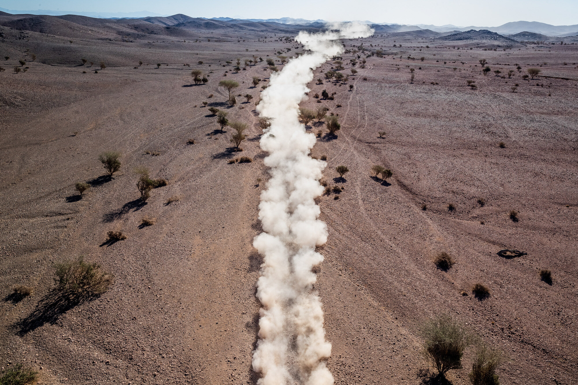 A trail of dust kicked up by a race car rises from the landscape during stage two of the Dakar Rally, between Al Wajh and Neom, Saudi Arabia on Jan. 6, 2020. (AP Photo/Bernat Armangue)