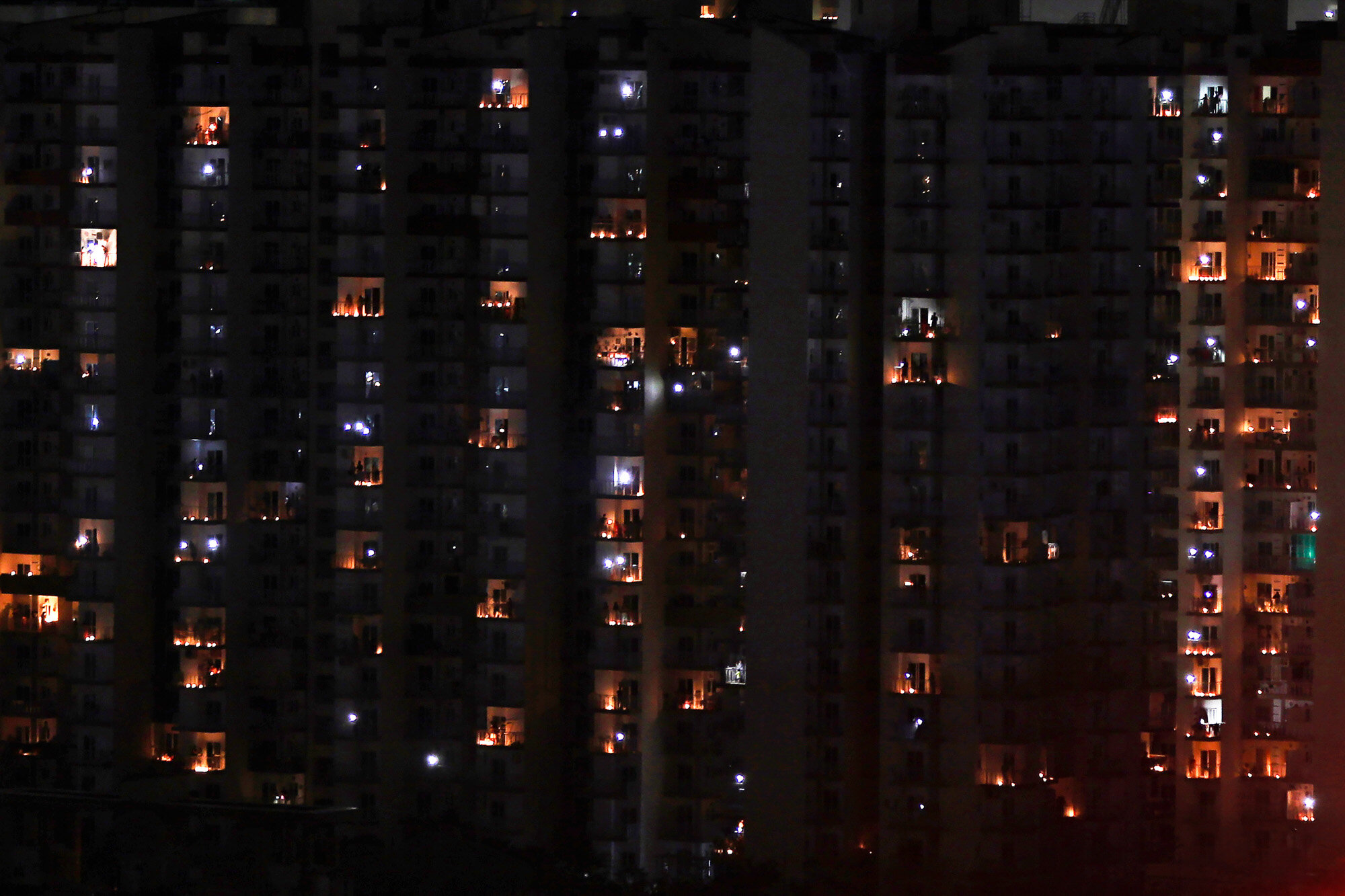 Balconies are illuminated with candles and torches to mark the country's fight against the coronavirus in Greater Noida, a suburb of New Delhi, India, on Sunday, April 5, 2020. (AP Photo/Altaf Qadri)