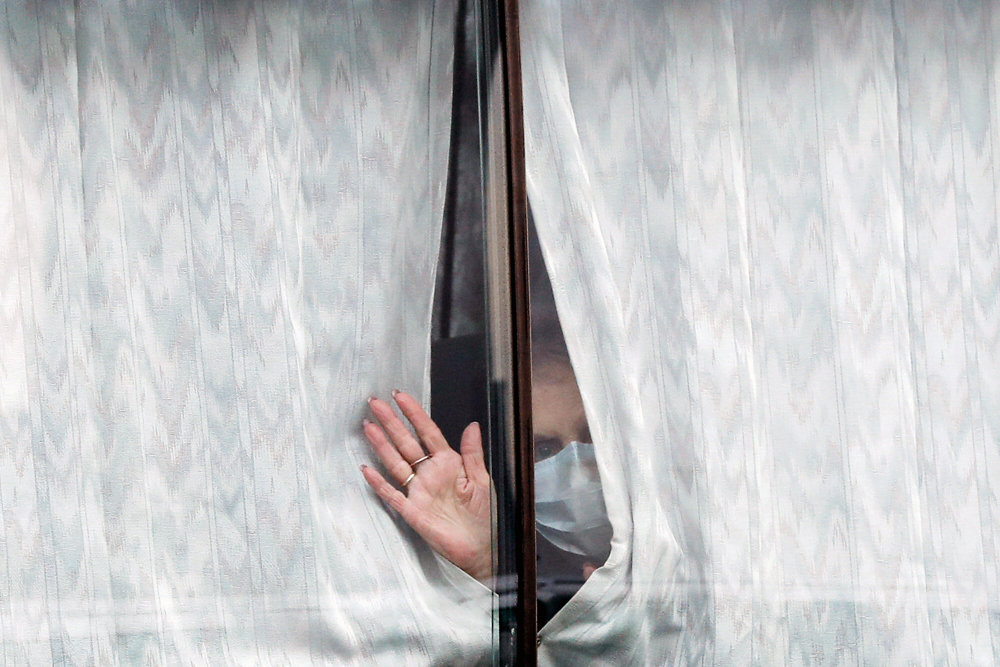A woman waves from a bus carrying passengers from the Diamond Princess cruise ship as they are transported from the port in Yokohama, near Tokyo on Feb. 20, 2020. The passengers had been quarantined on the cruise ship to curb the spread of the coronavirus. (AP Photo/Eugene Hoshiko)