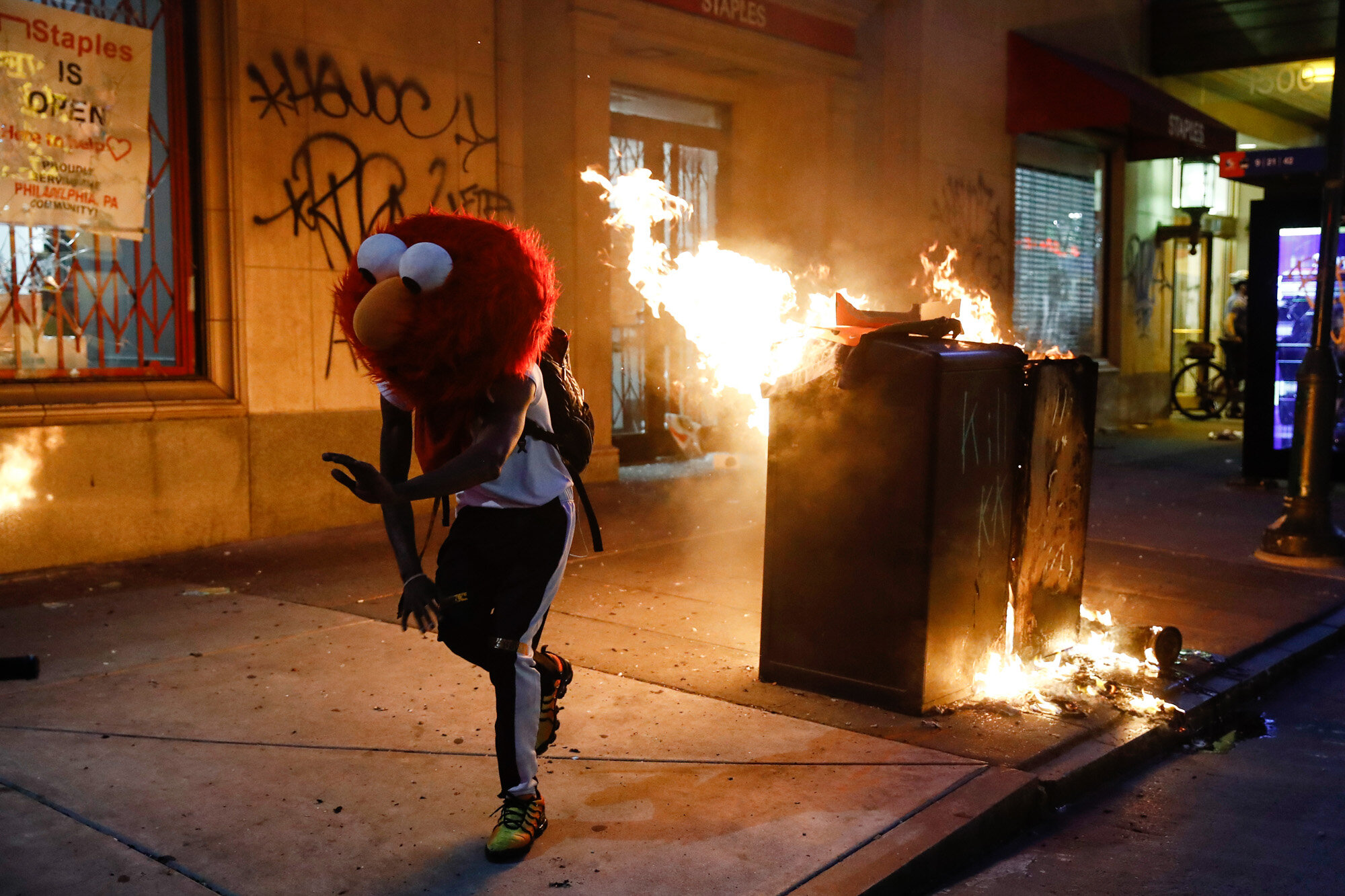 A protester in an Elmo mask dances as a street fire burns on May 30, 2020, during a protest in Philadelphia over the death of George Floyd, a Black man who was killed while in police custody in Minneapolis on May 25. (AP Photo/Matt Rourke)