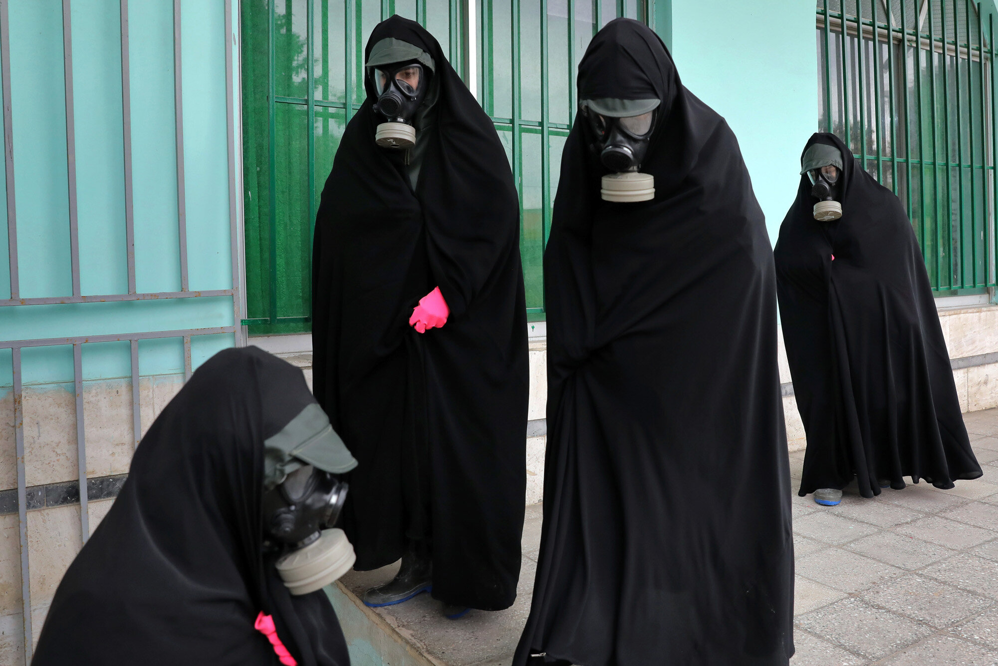 Women clerics wearing protective clothing and "chador," a head-to-toe garment, arrive at a cemetery to prepare the body of a person who died from COVID-19 for a funeral, in Ghaemshahr, Iran, on April 30, 2020. (AP Photo/Ebrahim Noroozi)