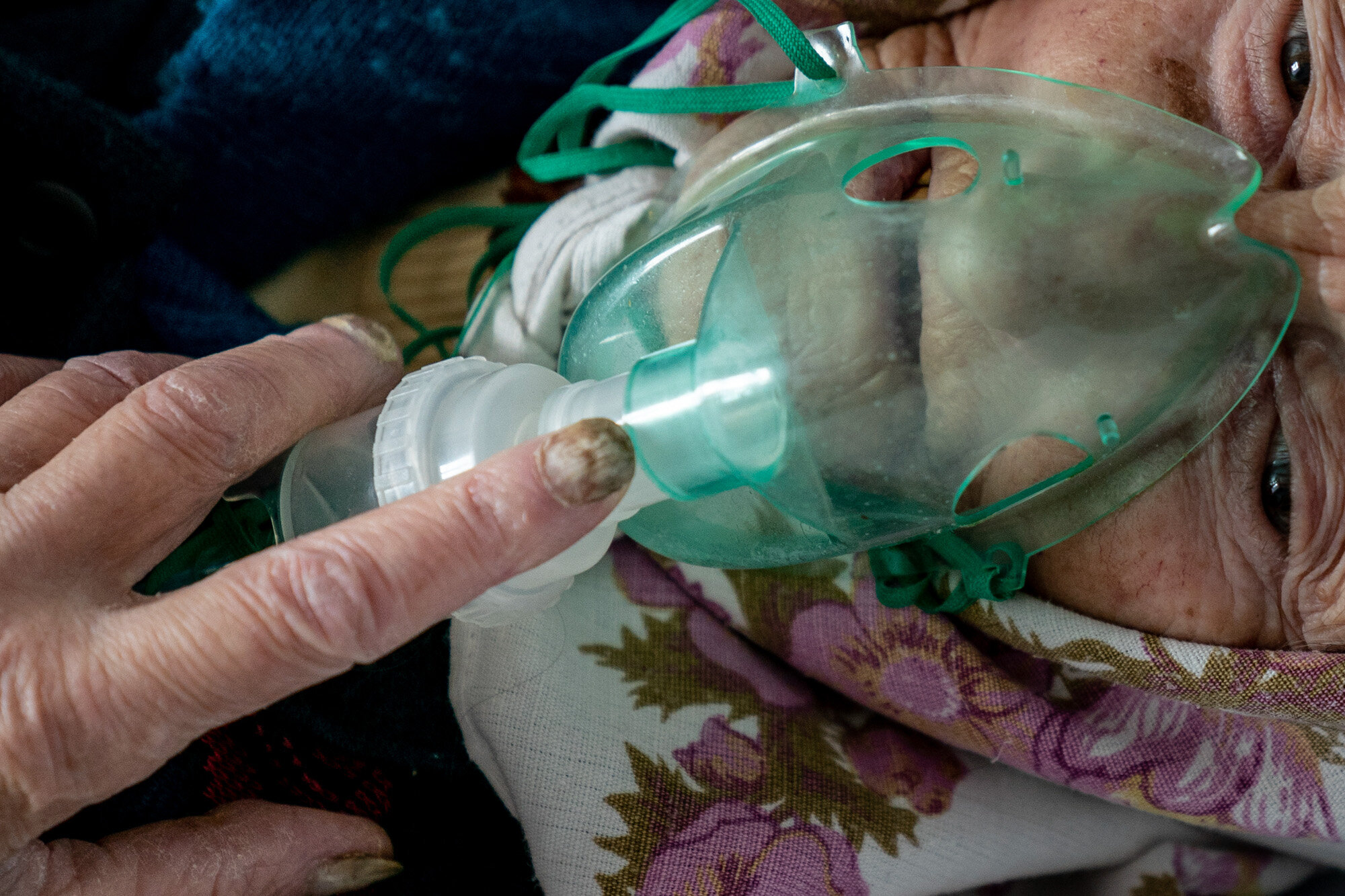 An elderly woman suffering from COVID-19 breathes with the help of an oxygen mask in a hospital in Pochaiv, Ukraine, on May 1, 2020. (AP Photo/Evgeniy Maloletka)