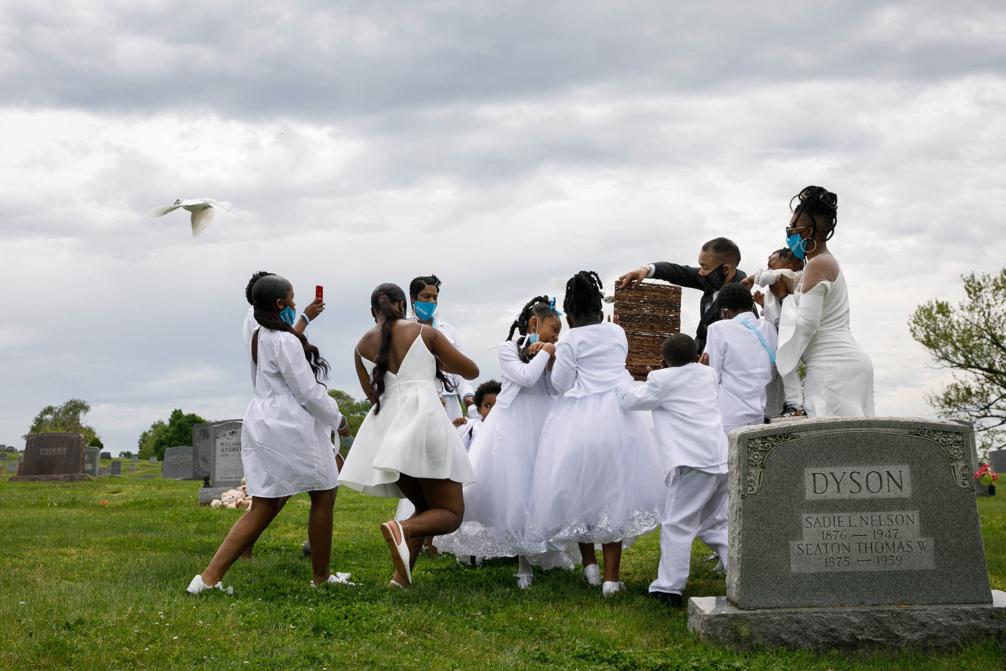 Grandchildren of Joanne Paylor, of southwest Washington, react to doves released during the interment ceremony for Paylor at Lincoln Memorial Cemetery in Suitland-Silver Hill, Md. on May 3, 2020. Although Paylor did not die from the coronavirus, almost every aspect of her funeral was affected by the pandemic. (AP Photo/Jacquelyn Martin)