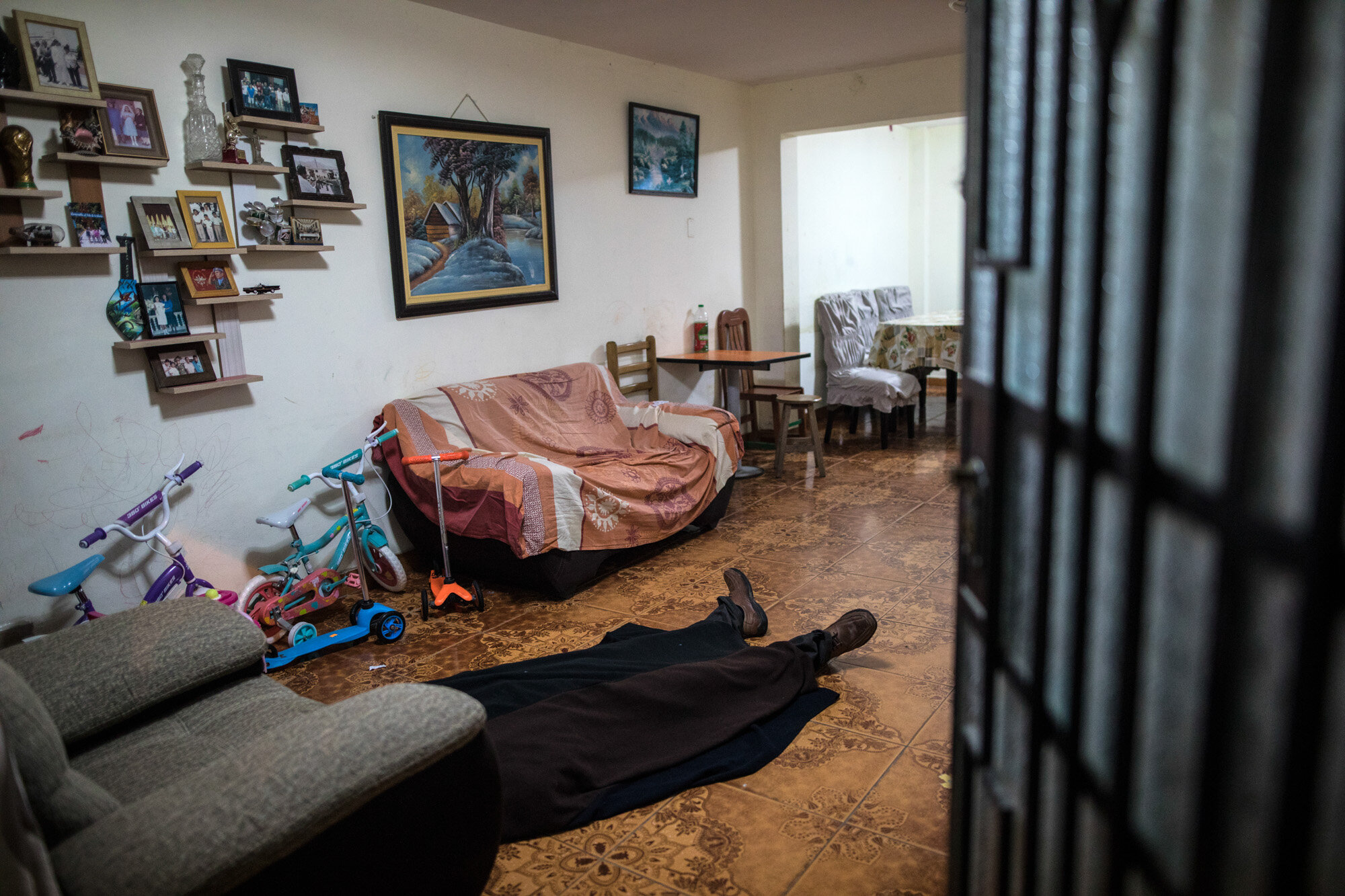 The body of Ricardo Noriega, 77, lies on the floor of his living room in Lima, Peru, on May 4, 2020, after he died of COVID-19. Noriega had great difficulty in breathing, one of the most characteristic symptoms of the disease, and waited for death sitting in an armchair in the living room after he was unable to find a taxi to take him to the hospital that morning. (AP Photo/Rodrigo Abd)