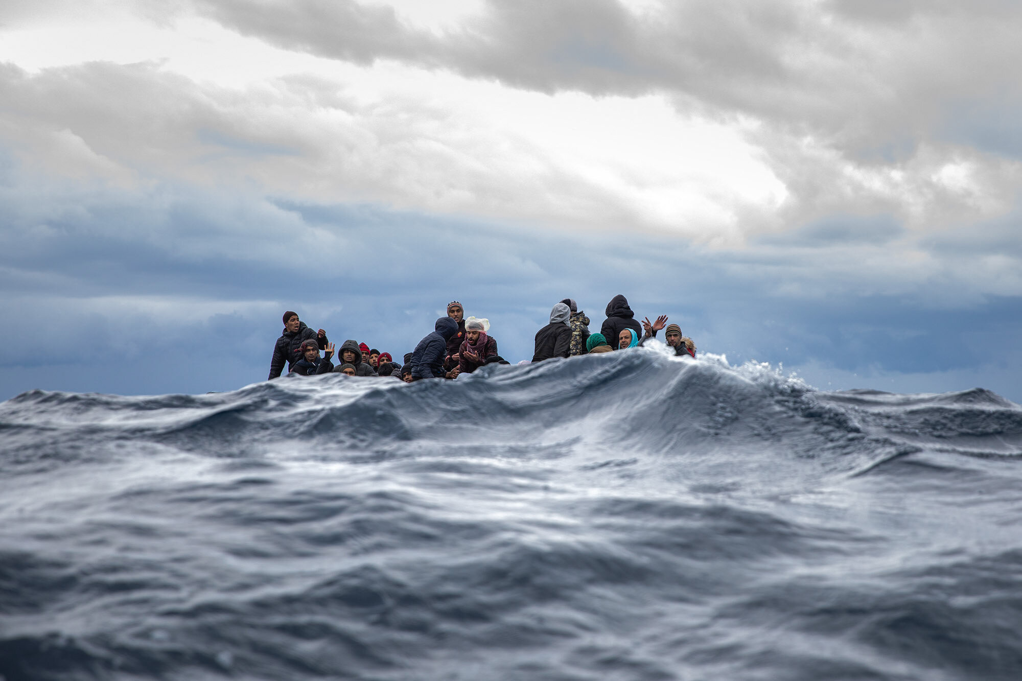 Moroccans and Bangladeshis wait on an overcrowded wooden boat for aid workers from the Spanish search and rescue group Open Arms off the Libyan coast on Jan. 10, 2020. (Santi Palacios)