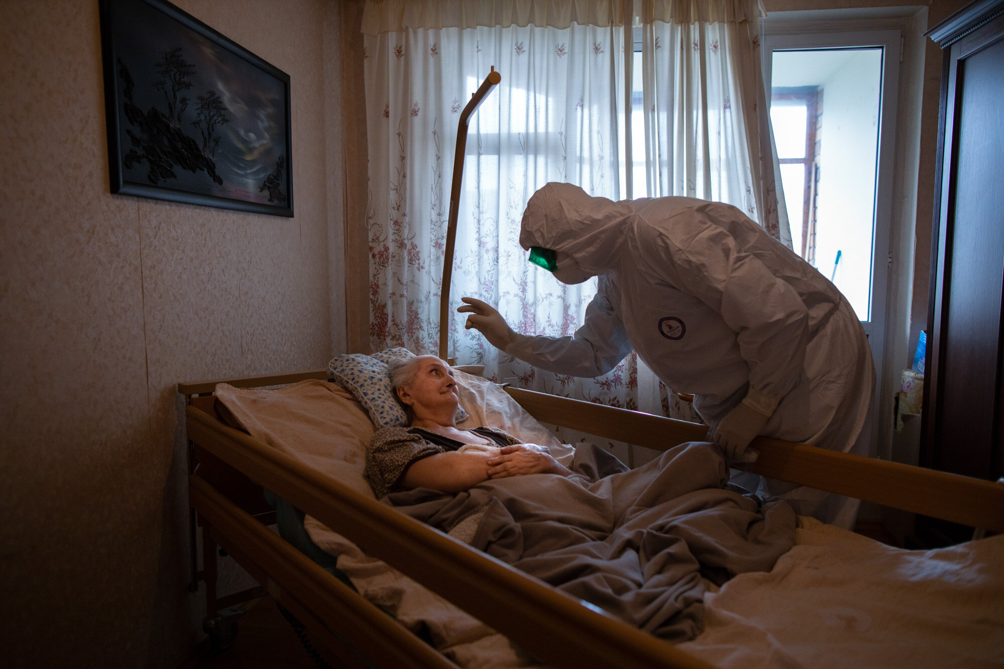 Father Vasily Gelevan, a Russian Orthodox priest, blesses Lyudmila Polyak, 86, who is believed to be suffering from COVID-19, at her apartment in Moscow. (AP Photo/Alexander Zemlianichenko)