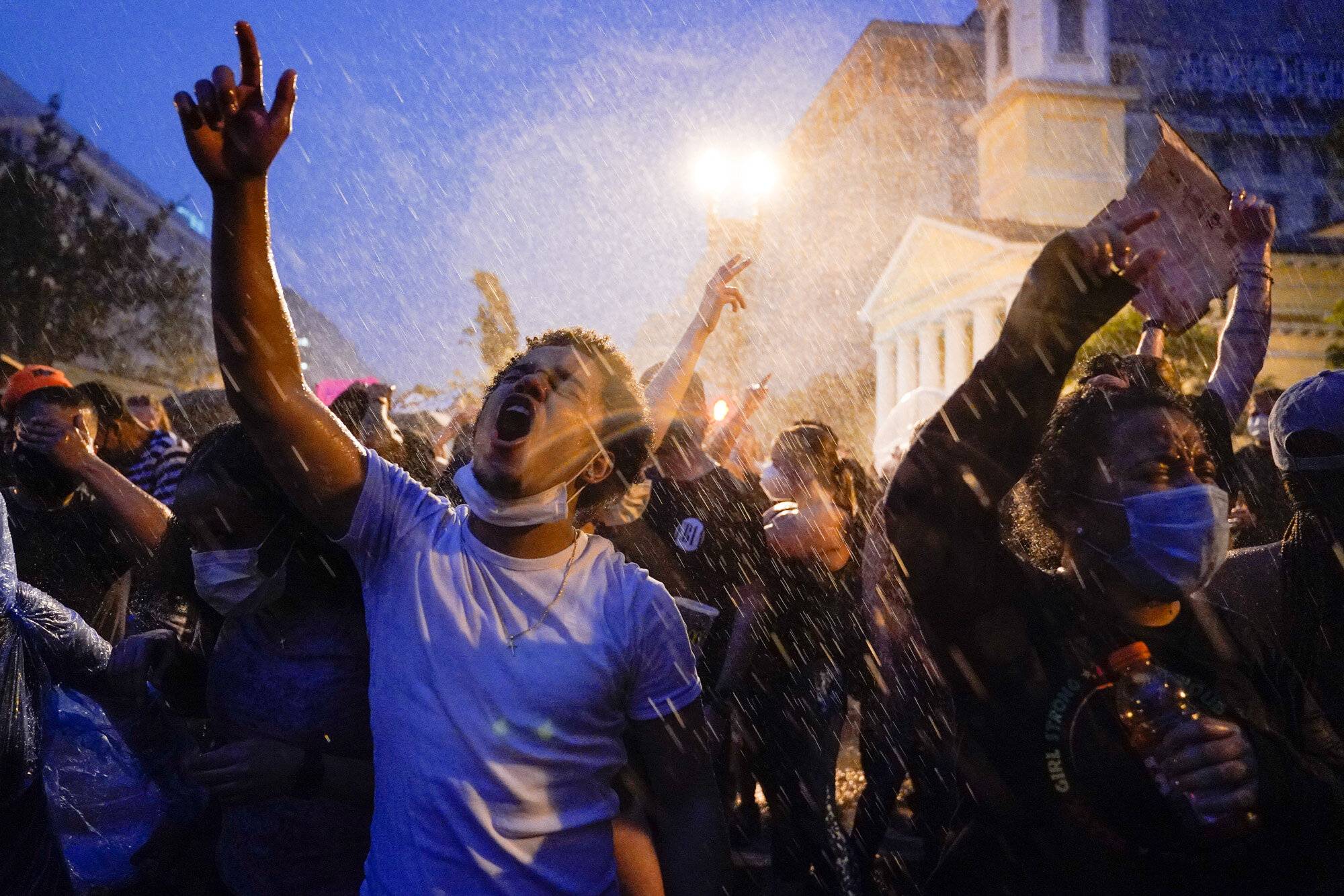 People protest in the rain near the White House in Washington on June 4, 2020, over the death of George Floyd, a Black man who died in Minneapolis after a white police officer pressed a knee into his neck for several minutes. (AP Photo/Evan Vucci)