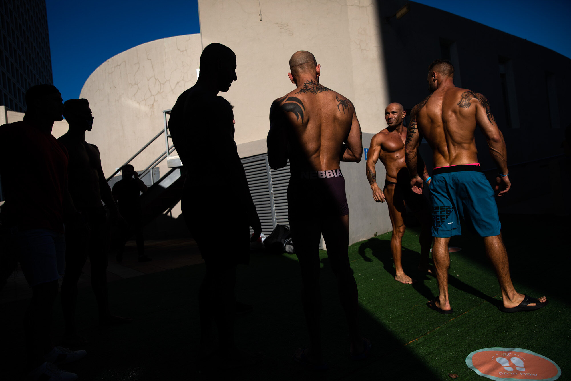 Contestants exercise backstage during the National Amateur Body Builders Association competition in Tel Aviv, Israel, on Aug. 19, 2020. Because of the coronavirus pandemic, this year’s competition was staged outdoors and the 85 participants were required to don protective masks in line with health codes. (AP Photo/Oded Balilty)