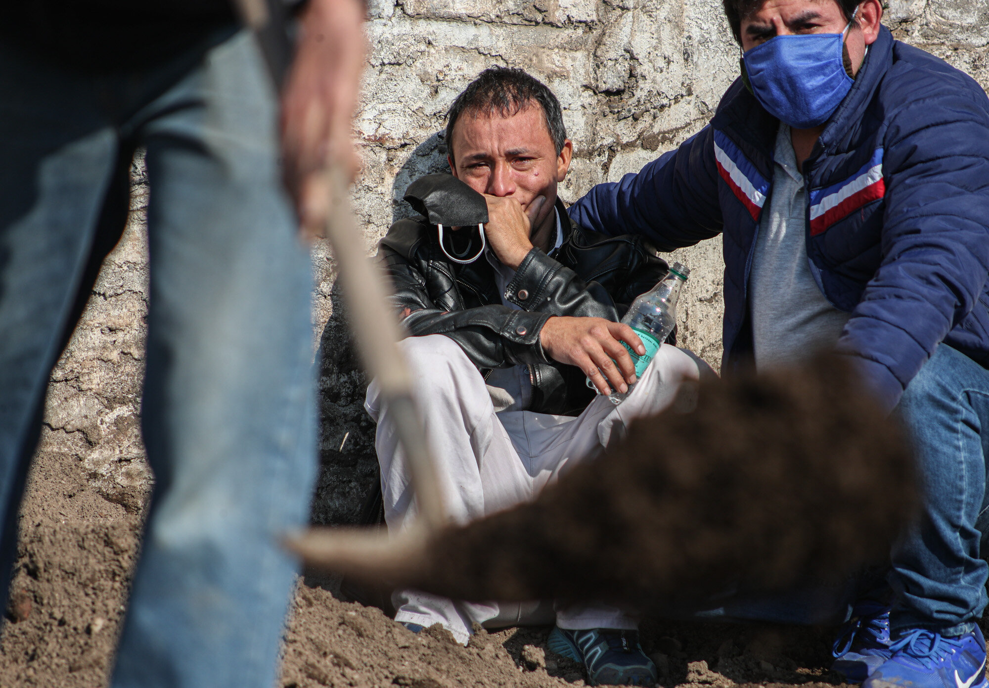 Peruvian migrant Jose Collantes cries as cemetery workers bury his wife Silvia Cano, who he says died of COVID-19, at a Catholic cemetery in Santiago, Chile, on July 3, 2020. Collantes said he preferred to cremate her in order to take the ashes home with him but, due to bureaucracy, had already been waiting two weeks. (AP Photo/Esteban Felix)