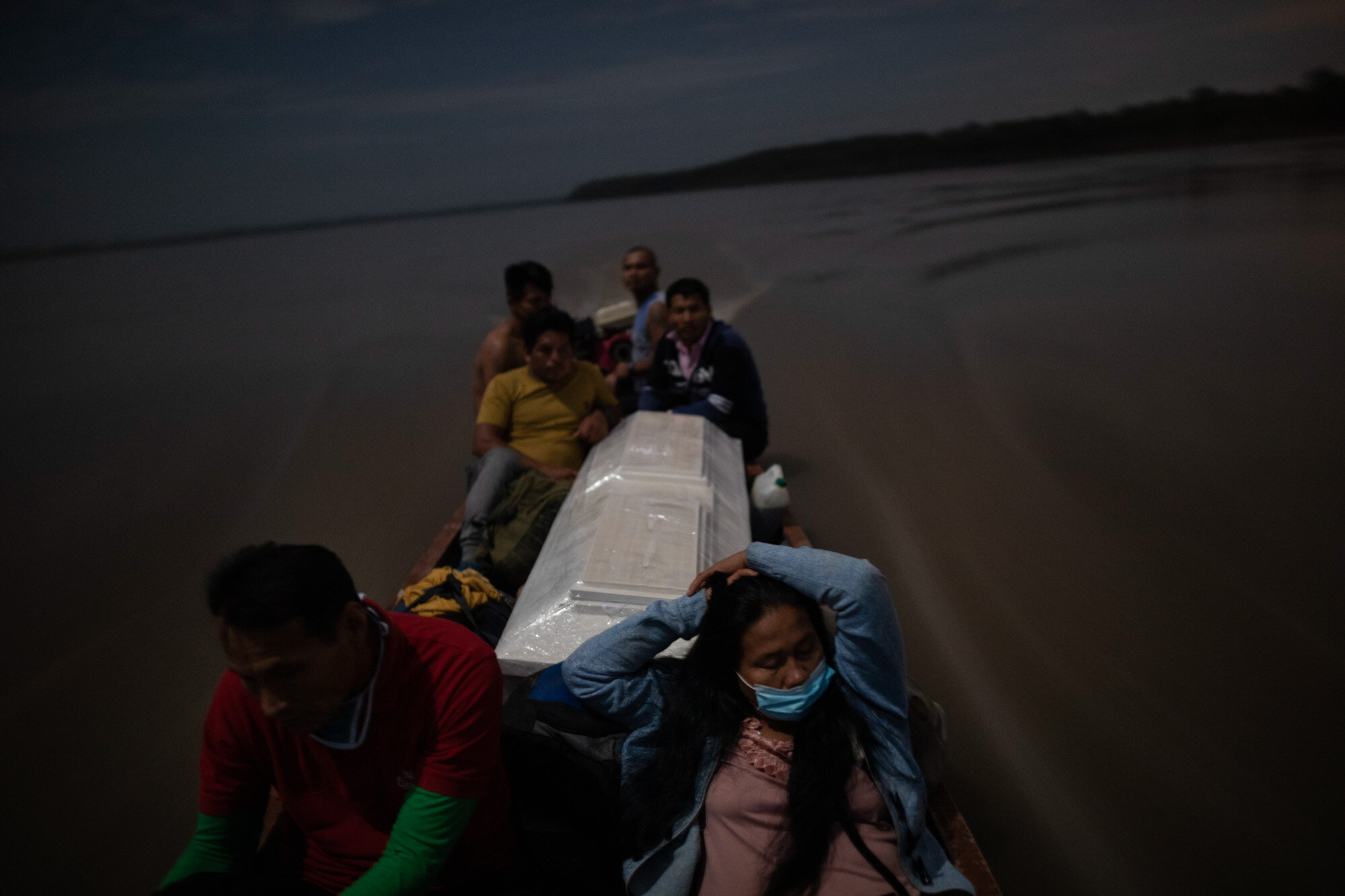  Relatives accompany the coffin that contains the remains of Jose Barbaran, who is believed to have died from complications related to the coronavirus, as they travel by boat on Peru's Ucayali River on Sept. 29, 2020. Despite the risk, family members