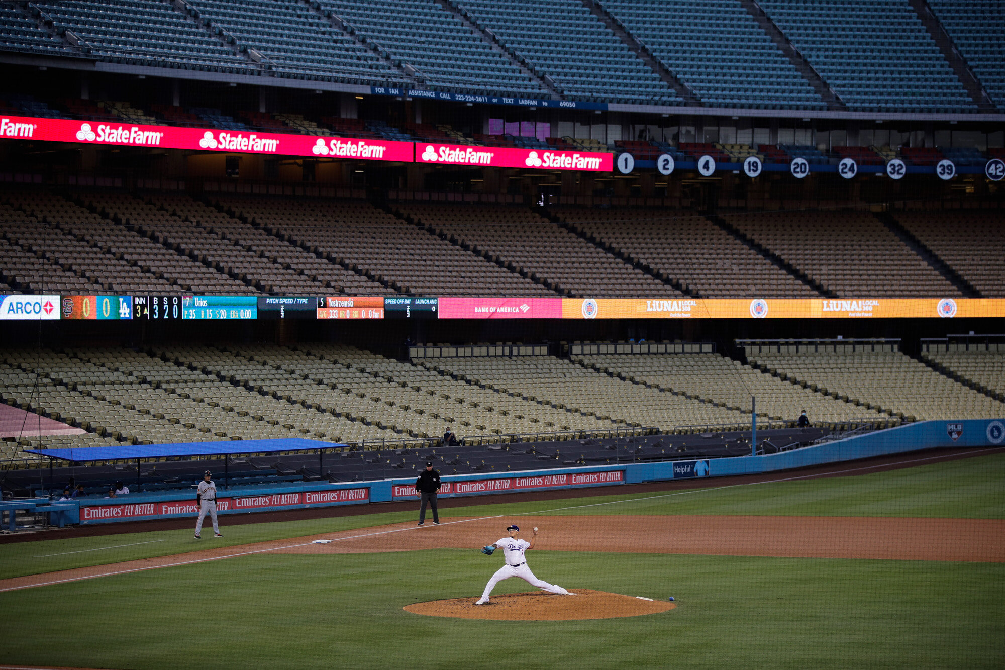 With the seats at Dodger Stadium empty, Los Angeles Dodgers starting pitcher Julio Urias throws to a San Francisco Giants batter during the third inning of a baseball game on July 26, 2020, in Los Angeles. (AP Photo/Jae C. Hong)