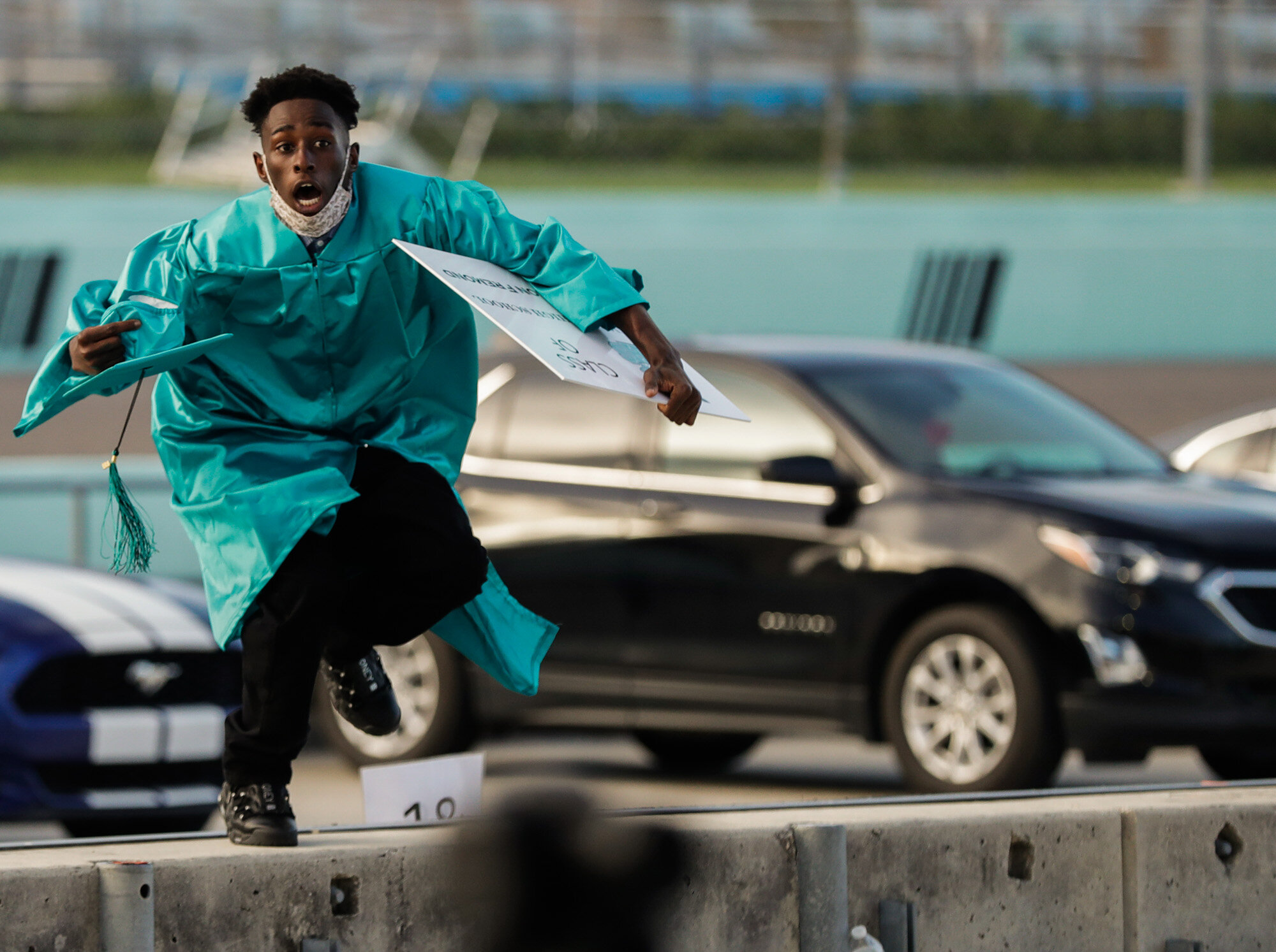  Richardson Fremond leaps over a wall as he runs to collect an award during the Chambers High School graduation ceremony at Homestead-Miami Speedway in Homestead, Fla., on June 23, 2020. The ceremony was held at the race track to enable social distan
