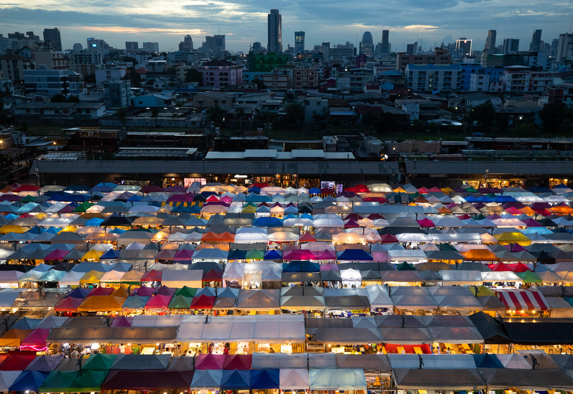 Tents of food stalls and other vendors are illuminated at Rot Fai Market in Bangkok, Thailand, on June 19, 2020, as the government continues to ease restrictions that were imposed to curb the spread of the coronavirus. (AP Photo/Sakchai Lalit)