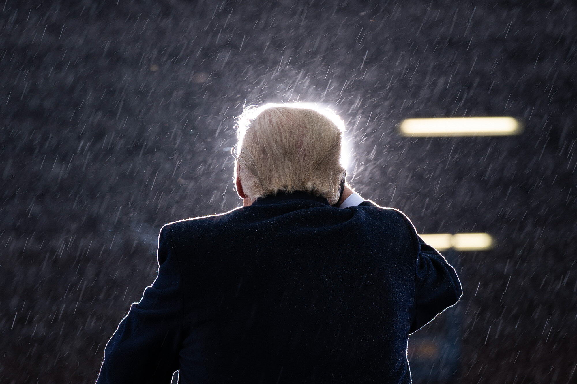 President Donald Trump speaks in the rain during a campaign rally at Capital Region International Airport in Lansing Mich., on Oct. 27, 2020. (AP Photo/Evan Vucci)