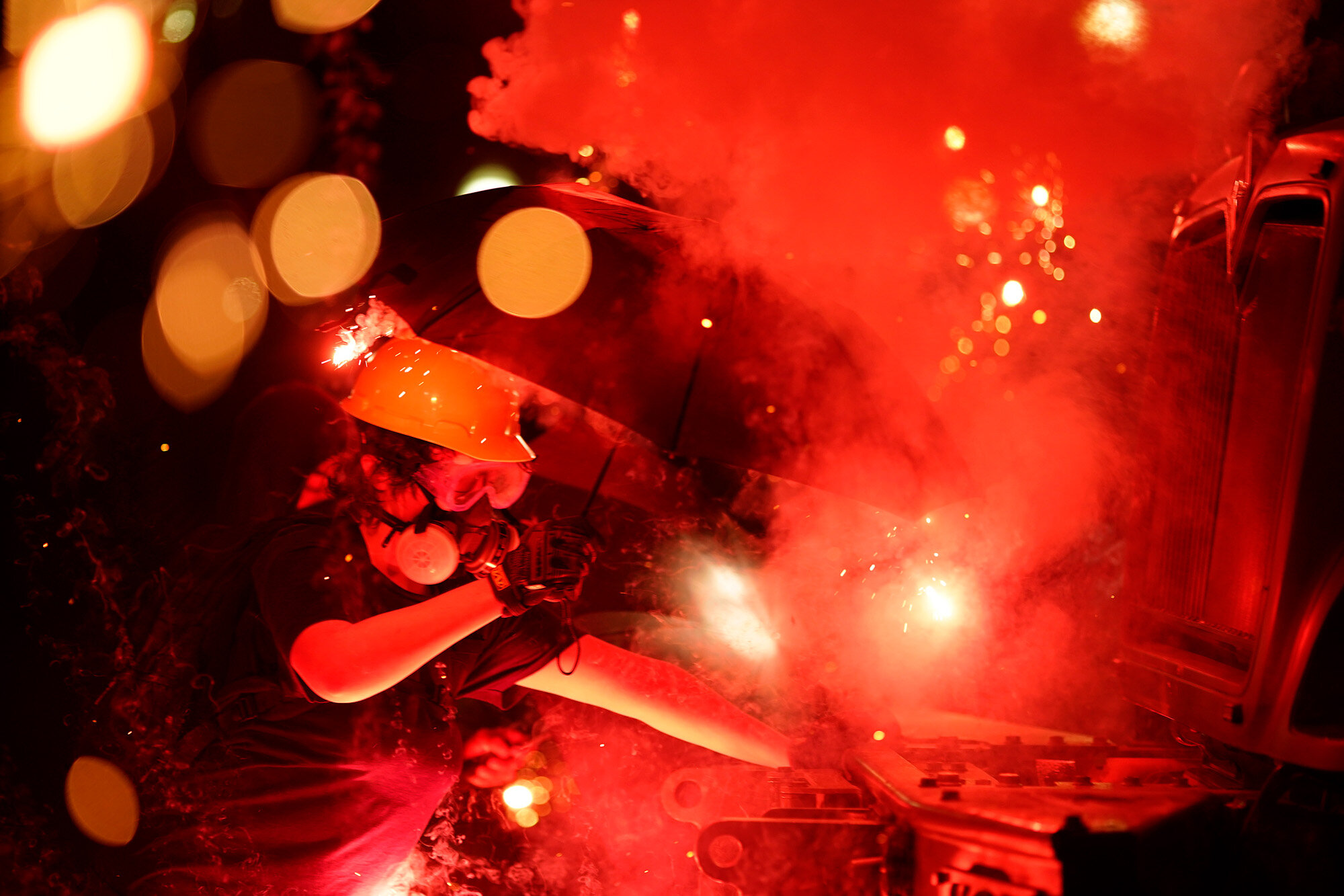 An explosive device detonates as a protester pushes back on an armored vehicle clearing the park of demonstrators during clashes outside the Kenosha County Courthouse late Tuesday, Aug. 25, 2020, in Kenosha, Wis. Protests have erupted following the police shooting of Jacob Blake two days earlier. (AP Photo/David Goldman)
