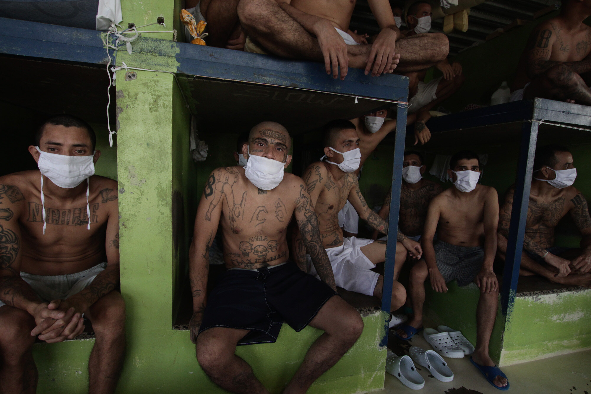 Imprisoned gang members, wearing protective face masks, sit inside a group cell during a media tour of the prison in Quezaltepeque, El Salvador, on Sept. 4, 2020. (AP Photo/Salvador Melendez)