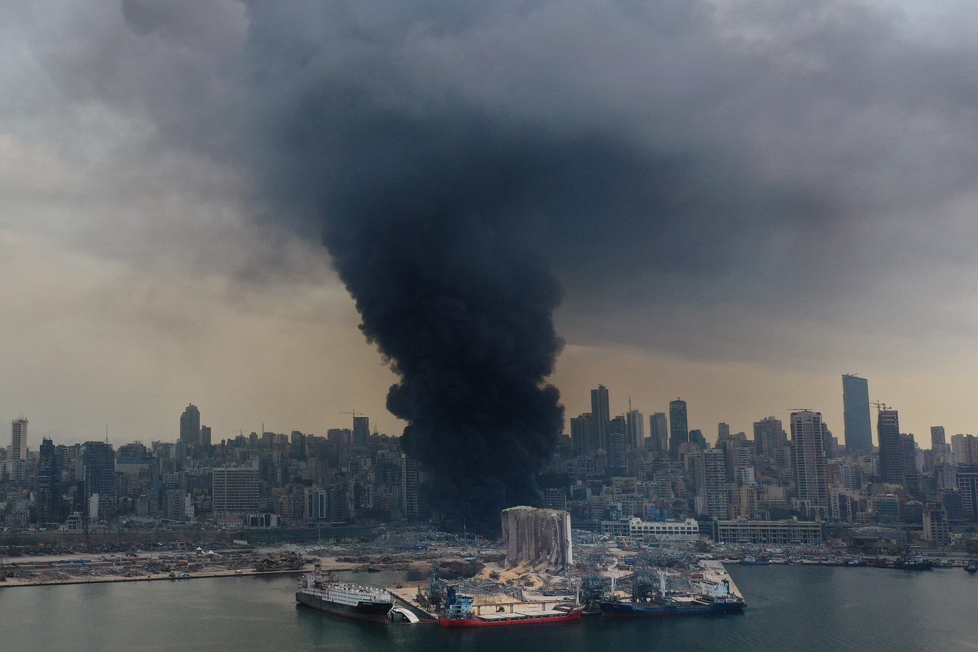 Black smoke rises from a warehouse fire at the Port of Beirut, Lebanon, on Sept. 10. 2020, triggering panic among residents traumatized by the massive explosion that killed and injured thousands of people the month before. (AP Photo/Hussein Malla)