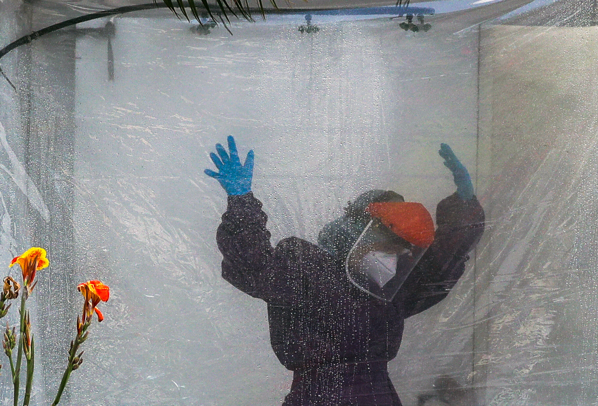 A health worker wearing a protective suit is disinfected in a portable tent outside the Gat Andres Bonifacio Memorial Medical Center in Manila, Philippines, on April 27, 2020, during an enhanced community quarantine to prevent the spread of the coronavirus. (AP Photo/Aaron Favila)