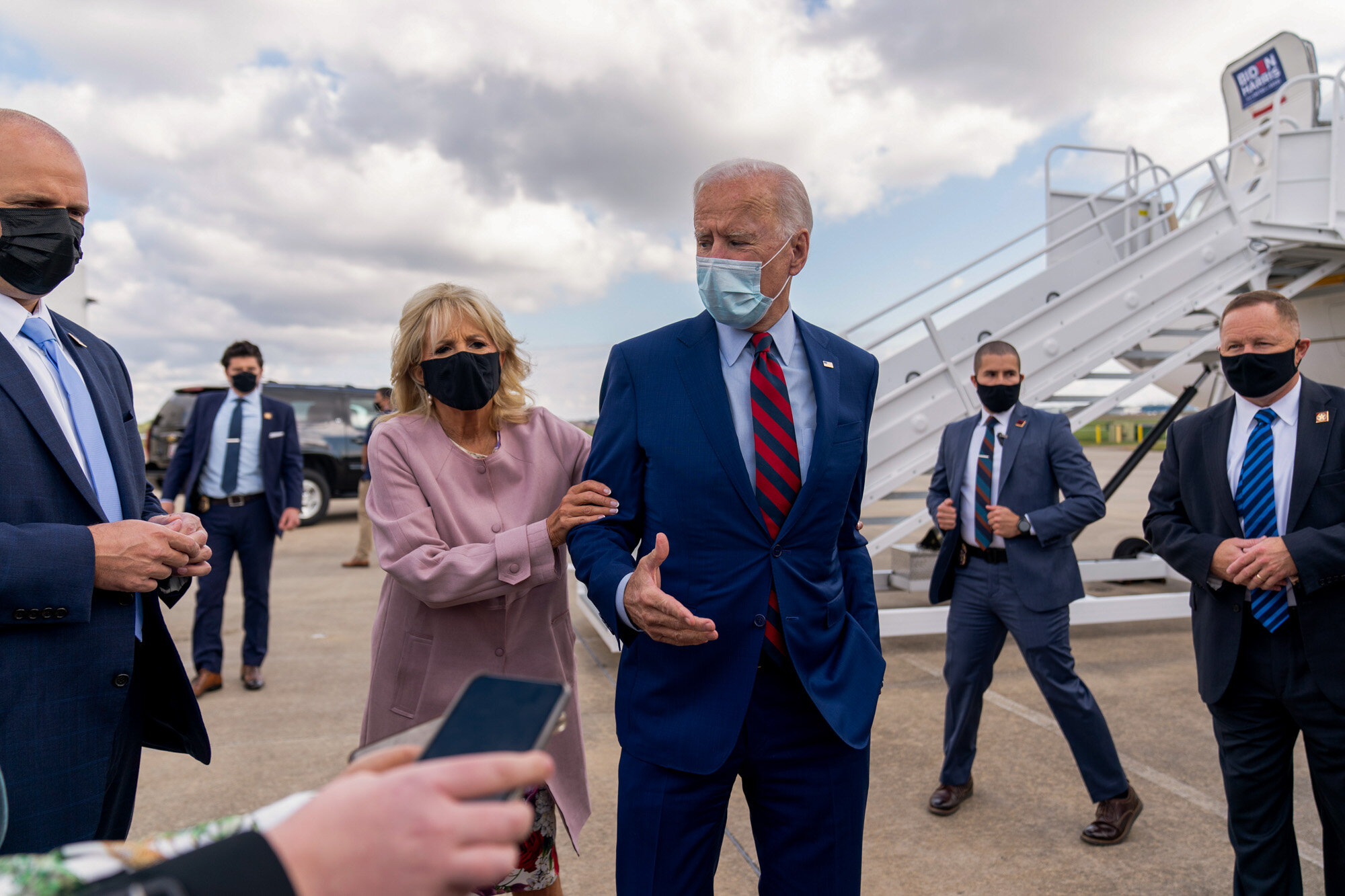 Jill Biden moves her husband, Democratic presidential candidate former Vice President Joe Biden, back from members of the media as he speaks outside his campaign plane in New Castle, Del., on Oct. 5, 2020. (AP Photo/Andrew Harnik)