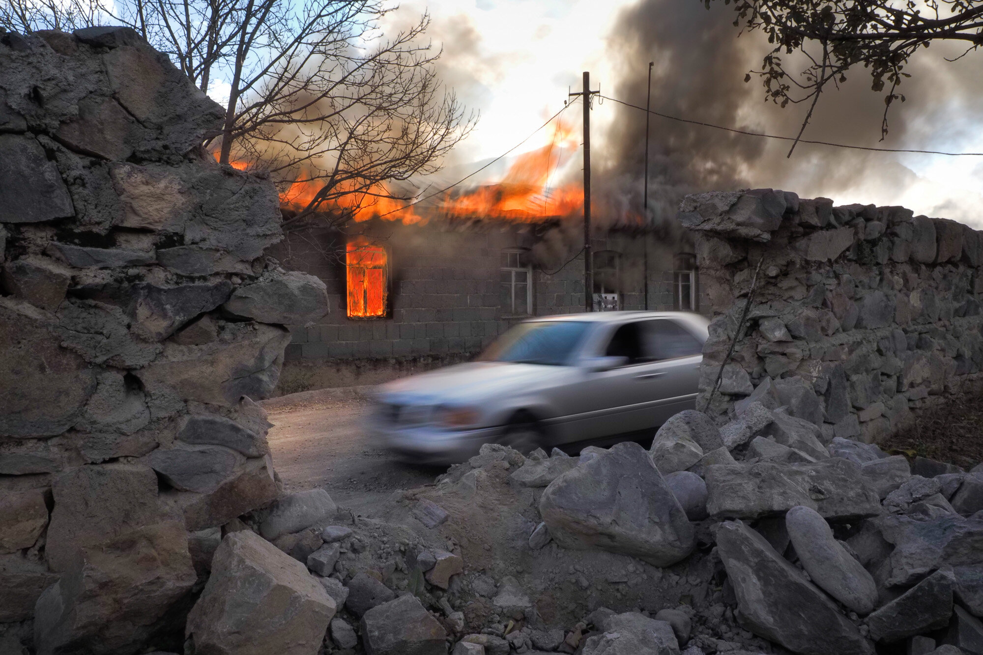 Smoke and flame rise from a burning house in an area once occupied by Armenian forces but soon to be turned over to Azerbaijan, in Karvachar, the separatist region of Nagorno-Karabakh, on Nov. 13, 2020. (AP Photo/Dmitry Lovetsky)