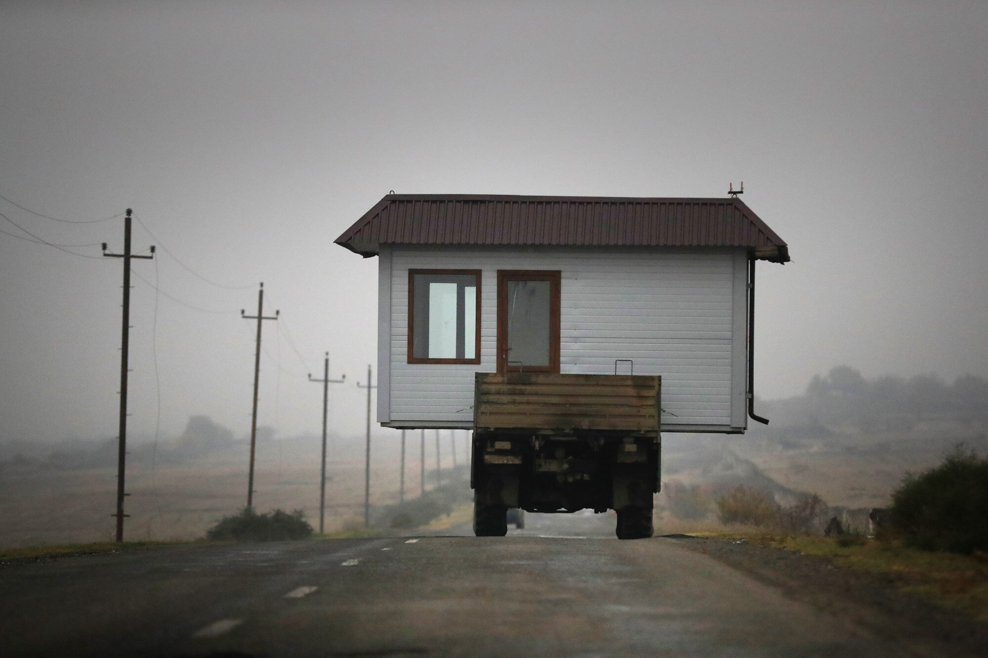  A family drives a truck loaded with a small house along a highway as they leave their home village in the separatist region of Nagorno-Karabakh on Nov. 18, 2020, before a cease-fire takes effect to halt weeks of fighting. Under the Russia-brokered a