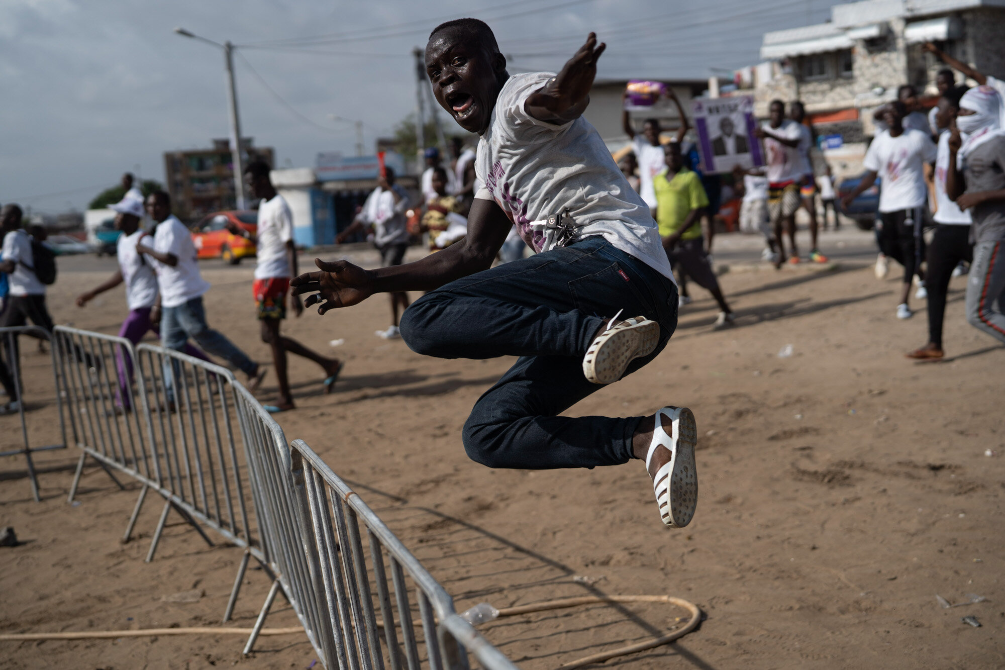 A supporter of presidential candidate Kouadio Konan Bertin jumps a fence as he arrives at Bertin’s final campaign rally in Abidjan, Ivory Coast, on Oct. 29, 2020, ahead of the Oct. 31 election. (AP Photo/Leo Correa)