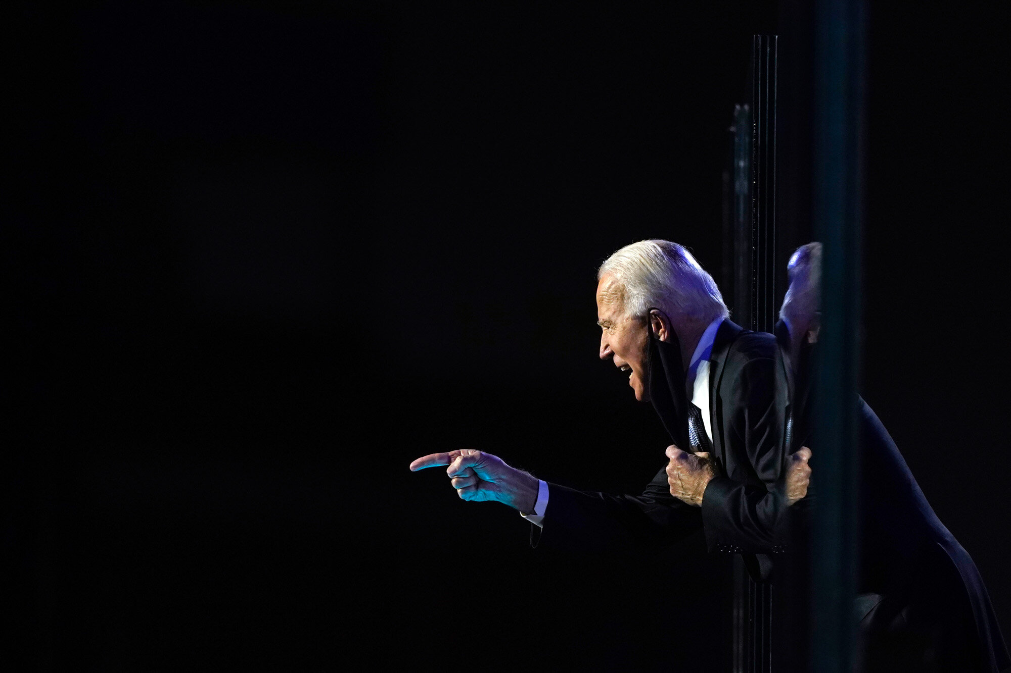 President-elect Joe Biden leans toward the cheering crowd, past the edge of protective glass on stage, on Saturday, Nov. 7, 2020, in Wilmington, Del. (AP Photo/Carolyn Kaster)