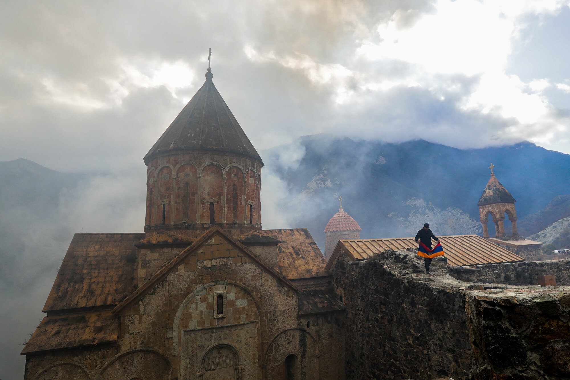  A man with an Armenian national flag visits the 12th-13th century Orthodox Dadivank Monastery on the outskirts of Kalbajar, in the separatist region of Nagorno-Karabakh, on Nov. 13, 2020. Under an agreement ending weeks of intense fighting over the 