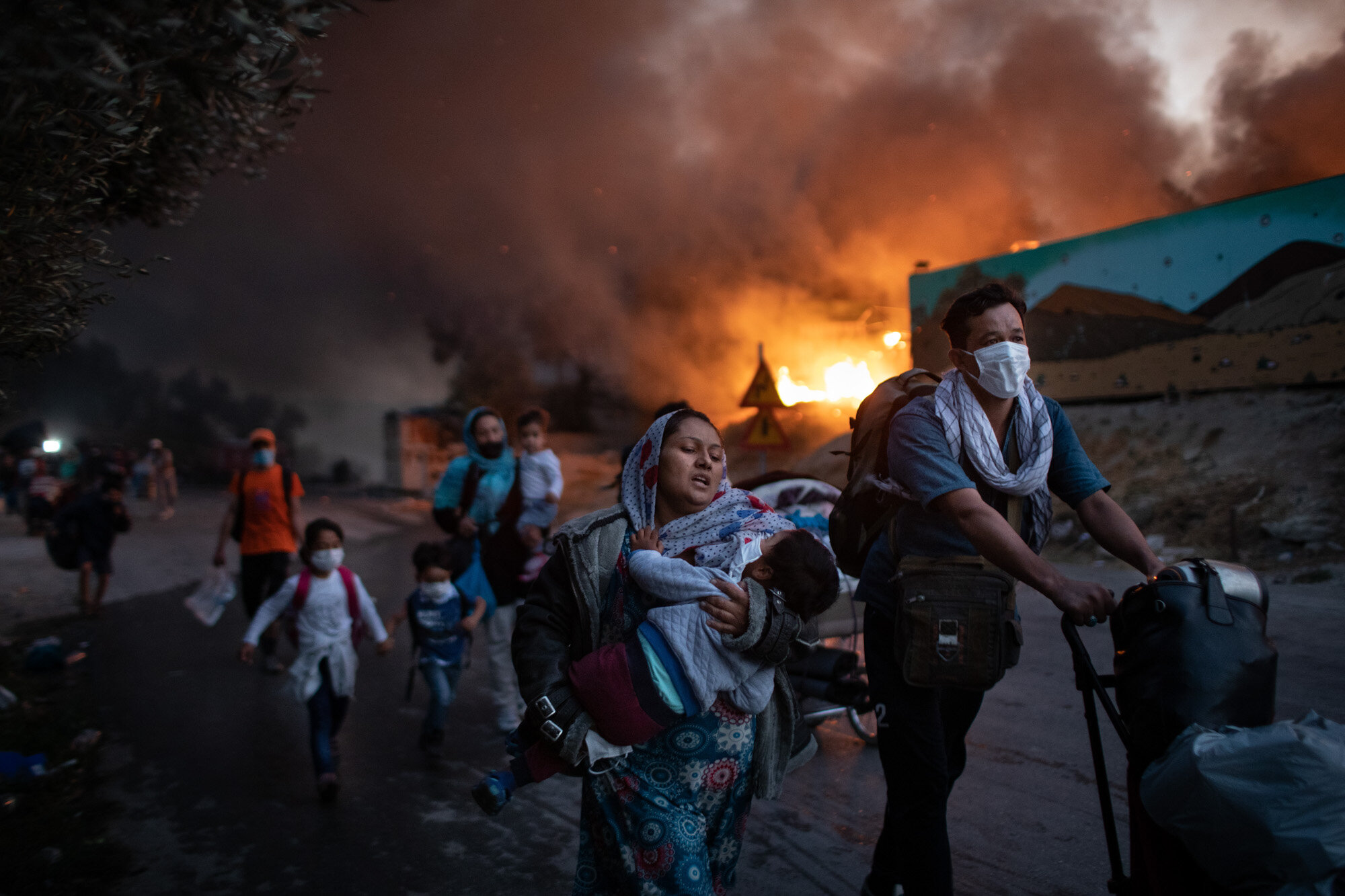 Migrants flee from the second fire in two days at the overcrowded Moria refugee camp on the island of Lesbos, Greece, on Sept. 9, 2020. (AP Photo/Petros Giannakouris)