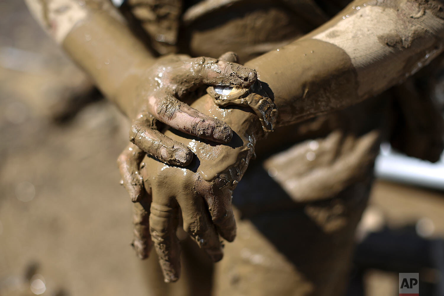  Gina Belchez wipes mud from her watch as she retrieves belongings from the typhoon-damaged Kasiglahan village in Rodriguez, Rizal province, Philippines on Friday, Nov. 13, 2020. (AP Photo/Aaron Favila) 