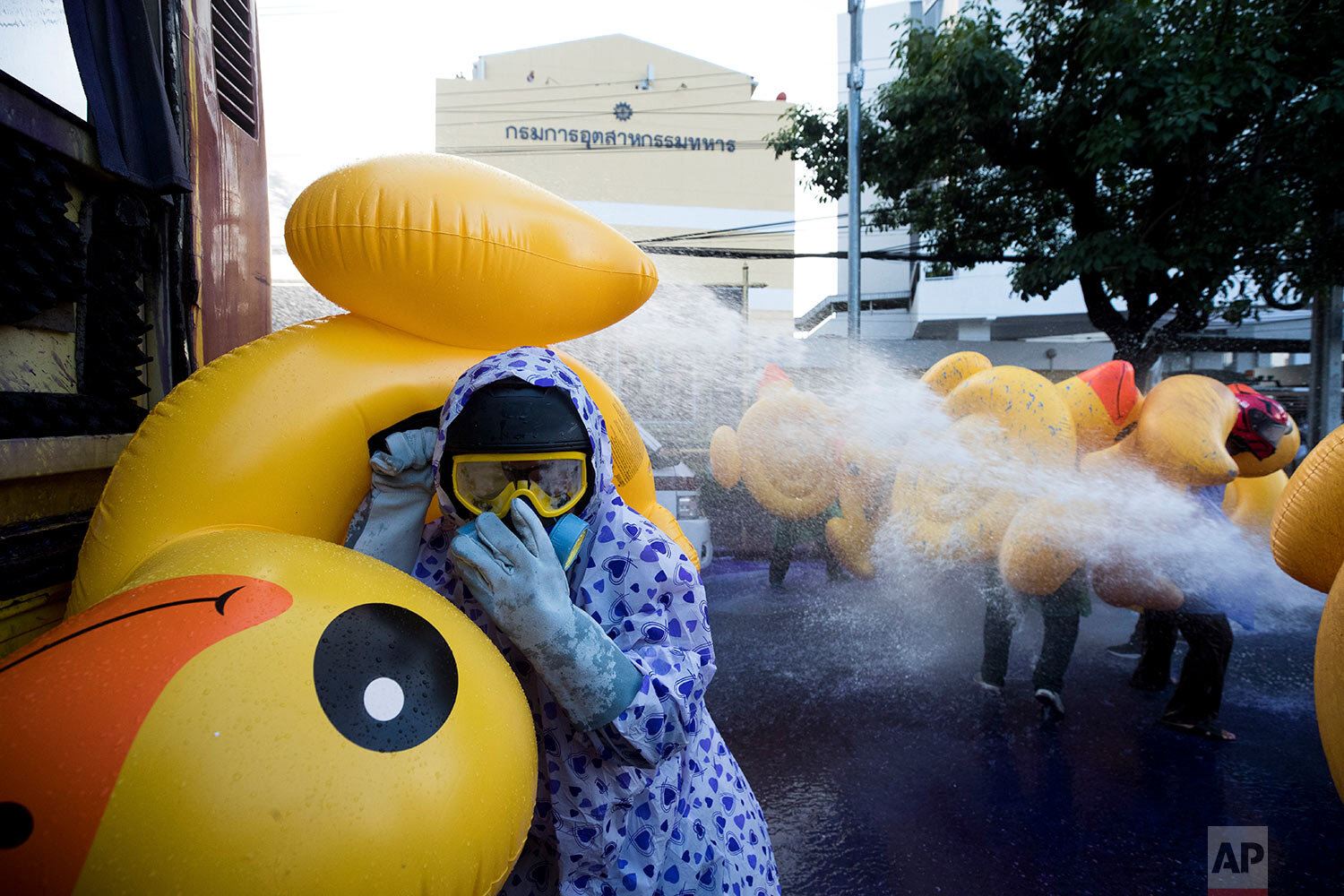  Pro-democracy protesters take cover with inflatable ducks, a current symbol of the protest movement, as police fire a water cannon during an anti-government rally near the Parliament in Bangkok, Tuesday, Nov. 17, 2020.  (AP Photo/Wason Wanichakorn) 