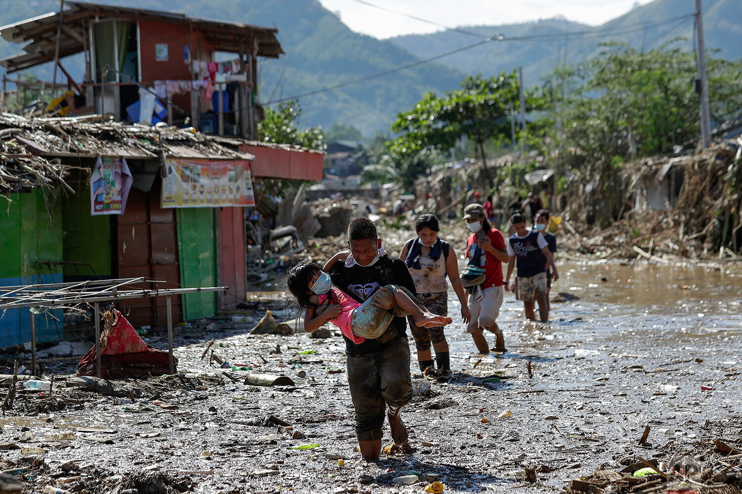  Residents cross debris and floods in the typhoon-damaged Kasiglahan village in Rodriguez, Rizal province, Philippines on Friday, Nov. 13, 2020. (AP Photo/Aaron Favila) 