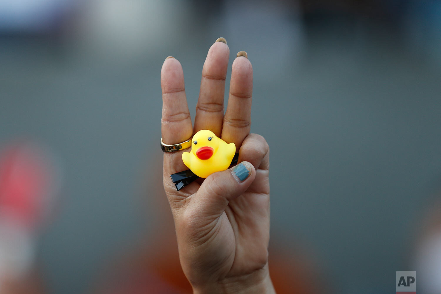  The three-finger protest gesture is flashed by a protester while holding a yellow duck, a current symbol of the protest movement, during anti-government rallies, Saturday, Nov. 28, 2020, in Bangkok, Thailand. (AP Photo/Sakchai Lalit) 