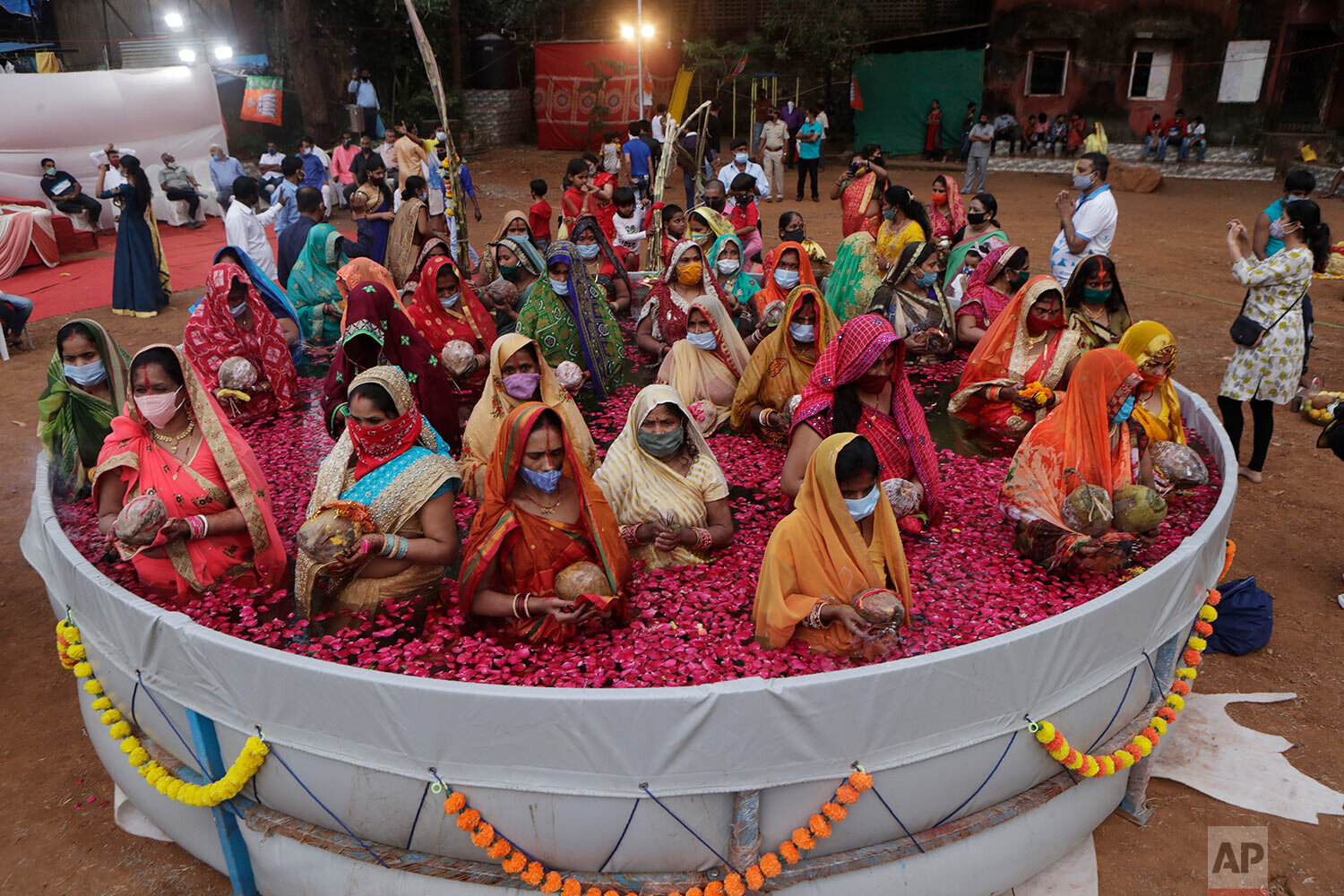  Indian women perform rituals standing inside an artificial pond on Chhat Puja festival in Mumbai, India, Friday, Nov. 20, 2020.  (AP Photo/Rajanish Kakade) 