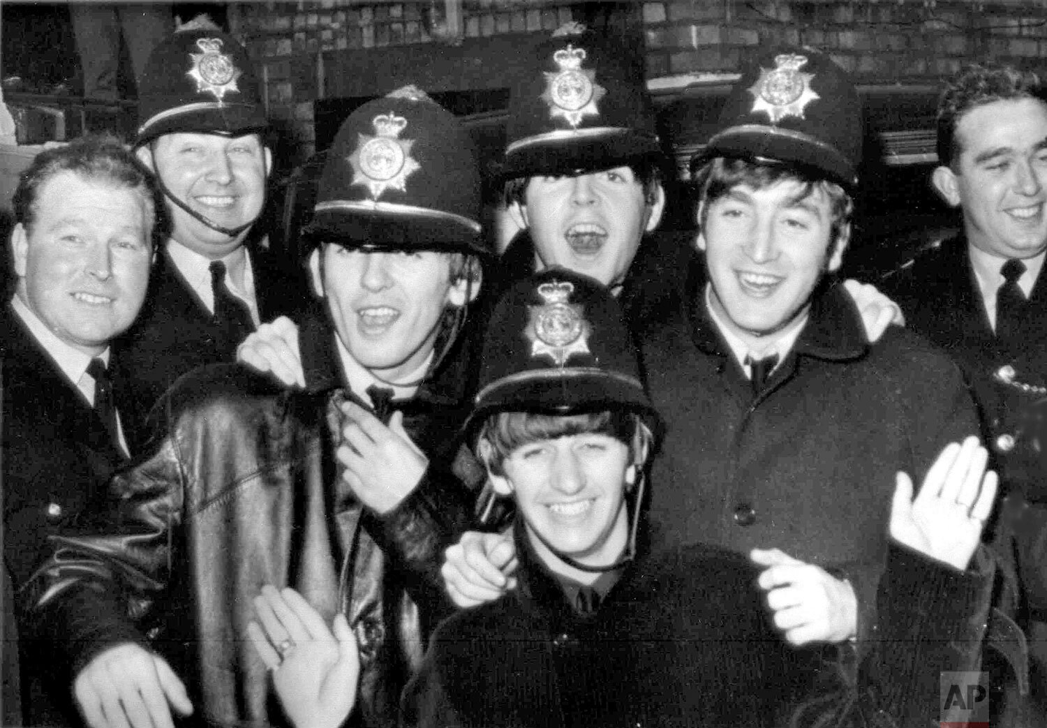  Britain's pop quartet The Beatles arrived almost unnoticed at the Hippodrome, Birmingham, Nov. 10, 1963, dressed as policemen. They are George Harrison, third left, Paul McCartney, John Lennon and Ringo Starr in front. Others in picture are real pol