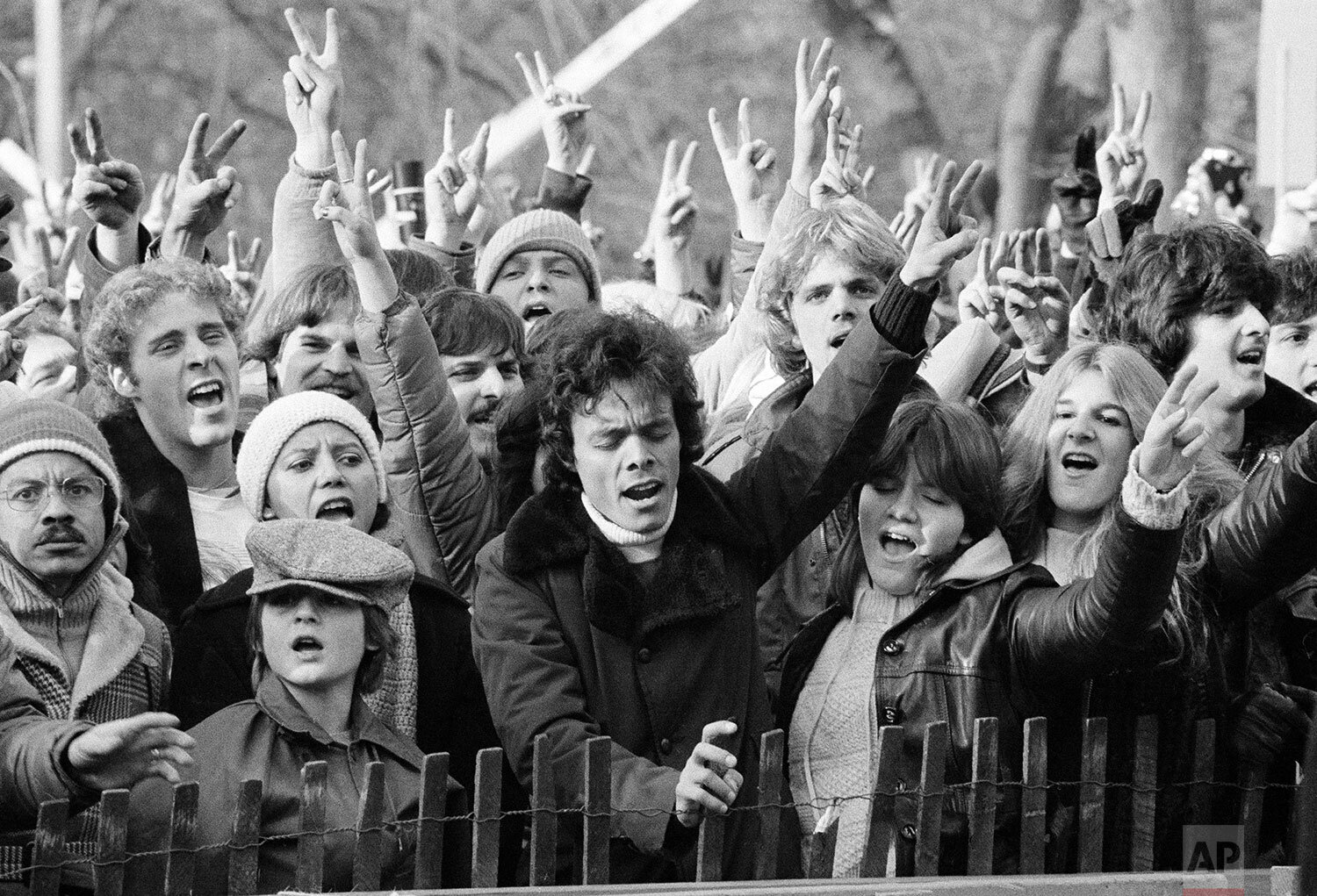  People participating in a tribute to the slain musician John Lennon wave the peace sign and sing "Give Peace A Chance" at New York's Central Park, Dec. 14, 1980. (AP Photo/Carlos Rene Perez) 
