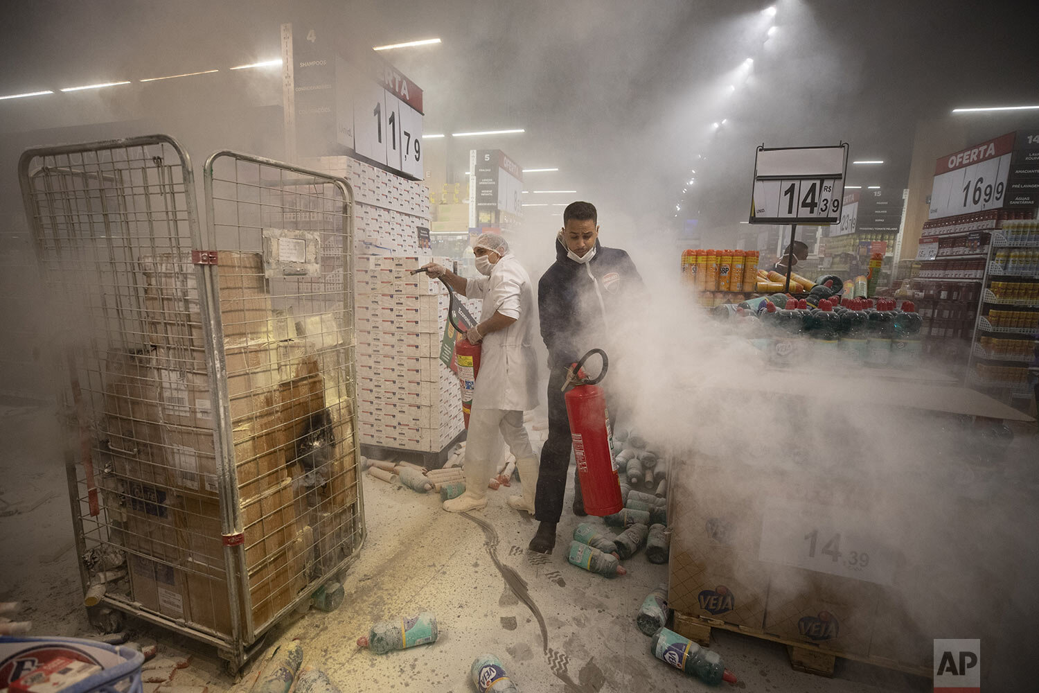  Employees douse a fire set by protesters inside a Carrefour supermarket during a protest against the murder of Black man Joao Alberto Silveira Freitas at a different Carrefour supermarket the night before, in Sao Paulo, Brazil, Friday, Nov. 20, 2020