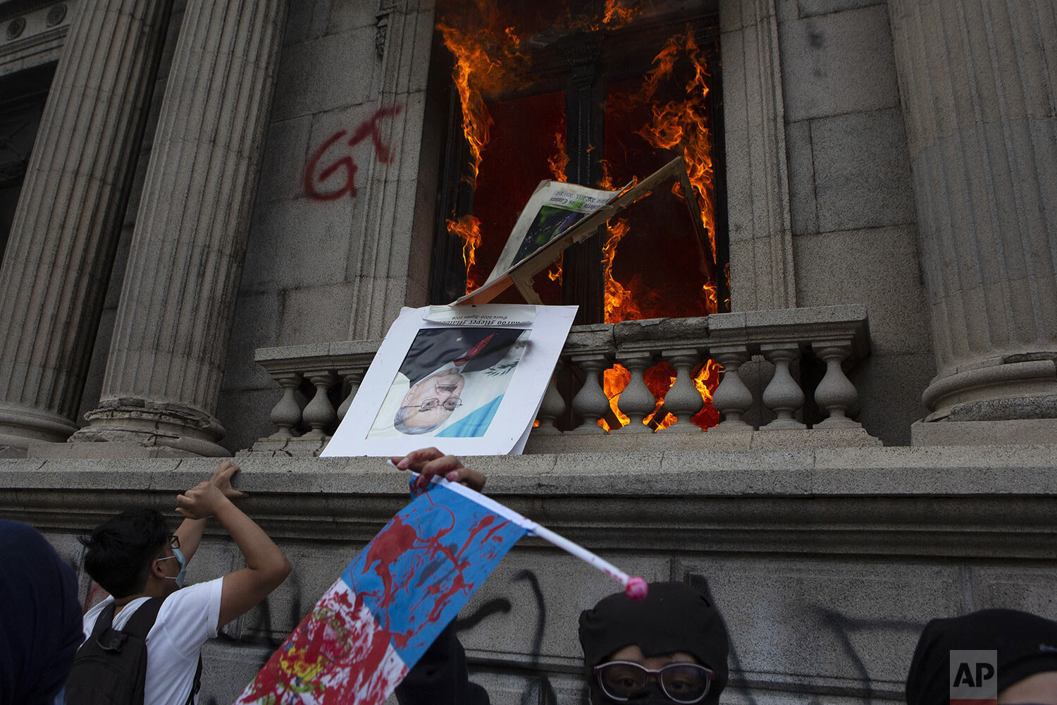  An official photo of former Congress President Eduardo Meyer is thrown out from the Congress building after protesters set a part of the building on fire, in Guatemala City, Saturday, Nov. 21, 2020. (AP Photo/Oliver De Ros) 