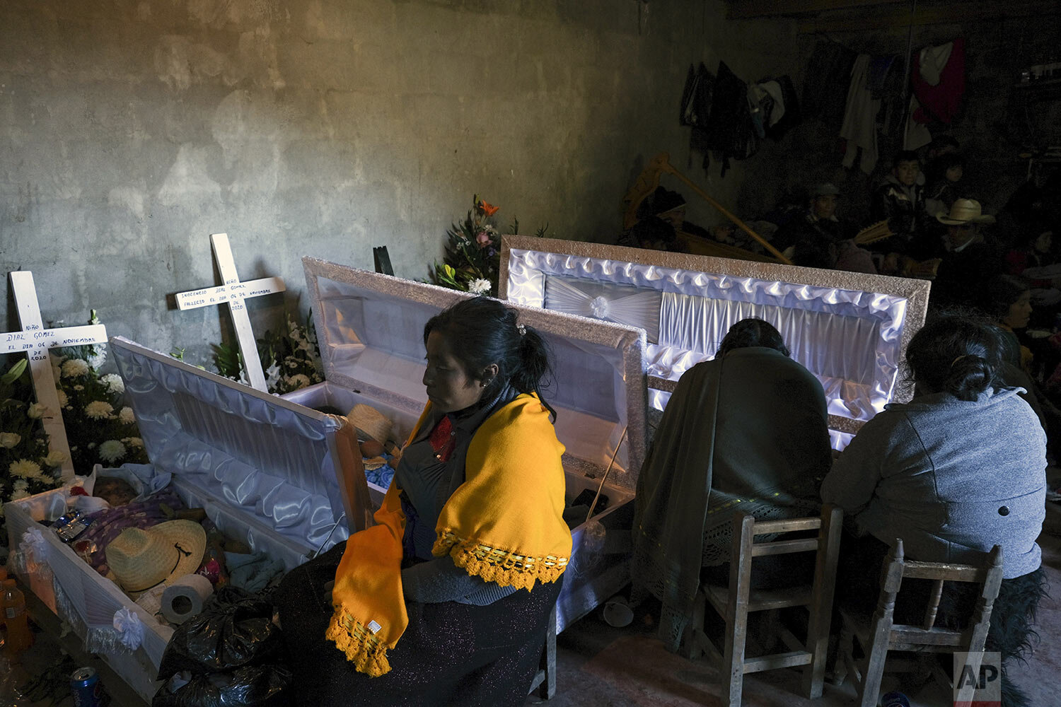  Mourners attend the wake of four members of a family who died when their home was washed away by flash floods in Mukem, Chiapas state, Mexico, Monday, Nov. 9, 2020.   (AP Photo/Isabel Mateos) 