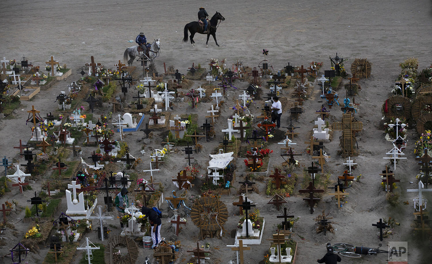  Workers ride their horses in the Valle de Chalco municipal cemetery, mostly reserved for the burials of COVID-19 victims, on the outskirts of Mexico City, Wednesday, Nov. 18, 2020. (AP Photo/Marco Ugarte) 