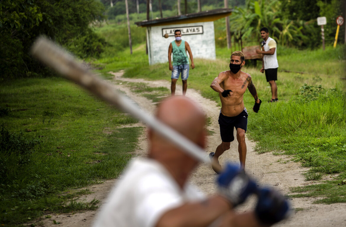  Locals play baseball wearing masks as a precaution against the spread of the new coronavirus in Las Playas neighborhood, in eastern Havana, Cuba, Wednesday, May 27, 2020. Cuban authorities are requiring the use of masks for anyone outside their home