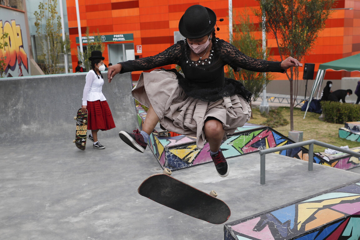  Aide Choque, wearing a mask amid the COVID-19 pandemic, jumps with her skateboard during a youth talent show in La Paz, Bolivia, Wednesday, Sept. 30, 2020. Young women called "Skates Imillas," using the Aymara word for girl Imilla, use traditional I