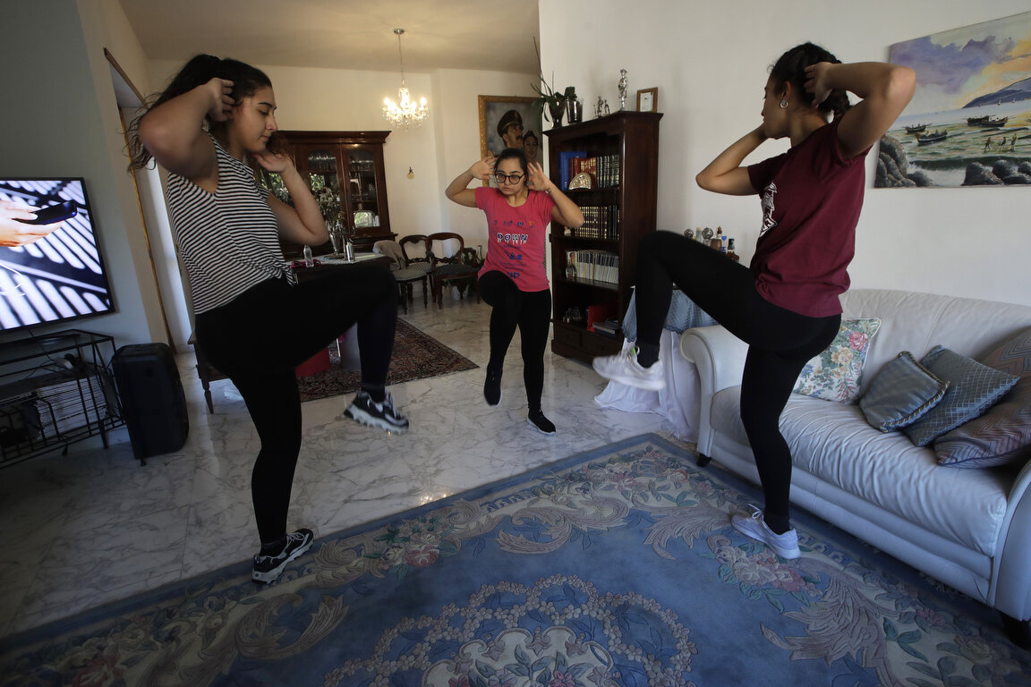  Selene Mirra, center, trains with her sisters, Aurora, left, and Sabrina in the living room of their home in Rome, Saturday, April 4, 2020. Selene, an athlete of the Italian down syndrome synchronized swimming team, continues her training despite th