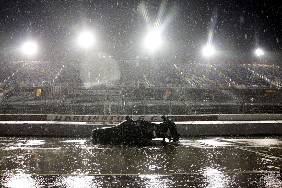  A crew pushes a car through the pit area at Darlington Raceway after the NASCAR Xfinity series auto race was postponed because of rain Tuesday, May 19, 2020, in Darlington, S.C. (AP Photo/Brynn Anderson) 