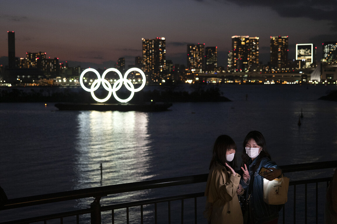  Women take a selfie with the Olympic rings in the background in the Odaiba section of Tokyo, Thursday, March 12, 2020. Tokyo Governor Yuriko Koike spoke Thursday after the World Health Organization labeled the spreading virus a "pandemic," a decisio