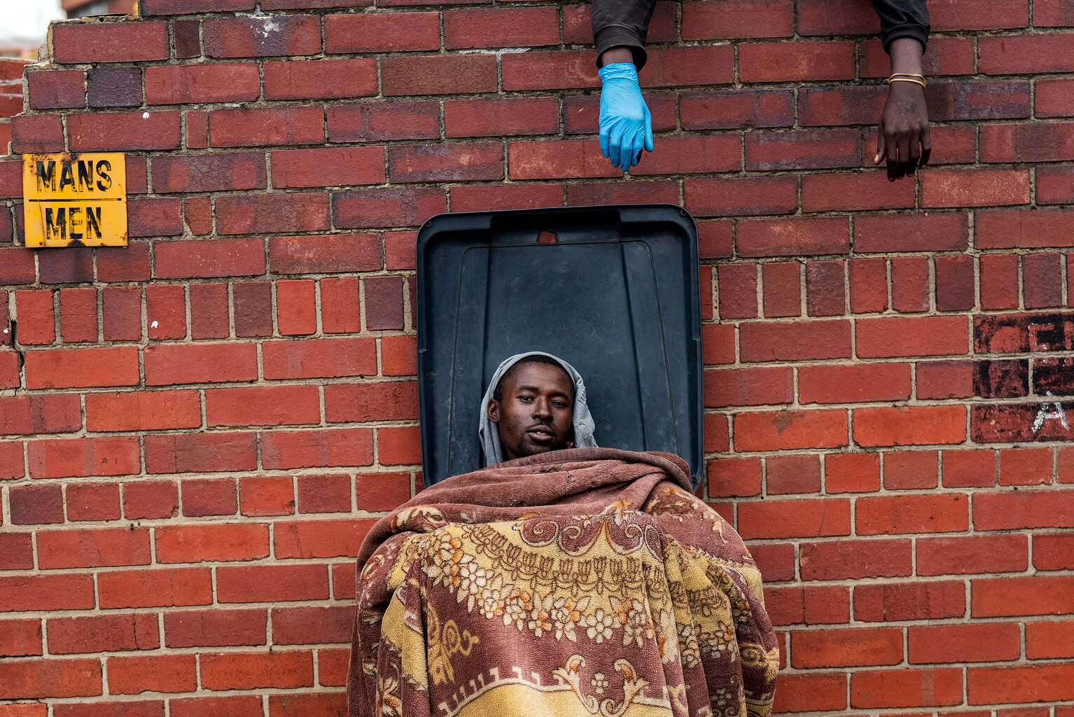  Henry sits in a trash bin as he and other homeless people rest at the Caledonian stadium in downtown Pretoria, South Africa, Thursday April 2, 2020, after being rounded up by police in an effort to enforce a 21-day lockdown to control the spread of 