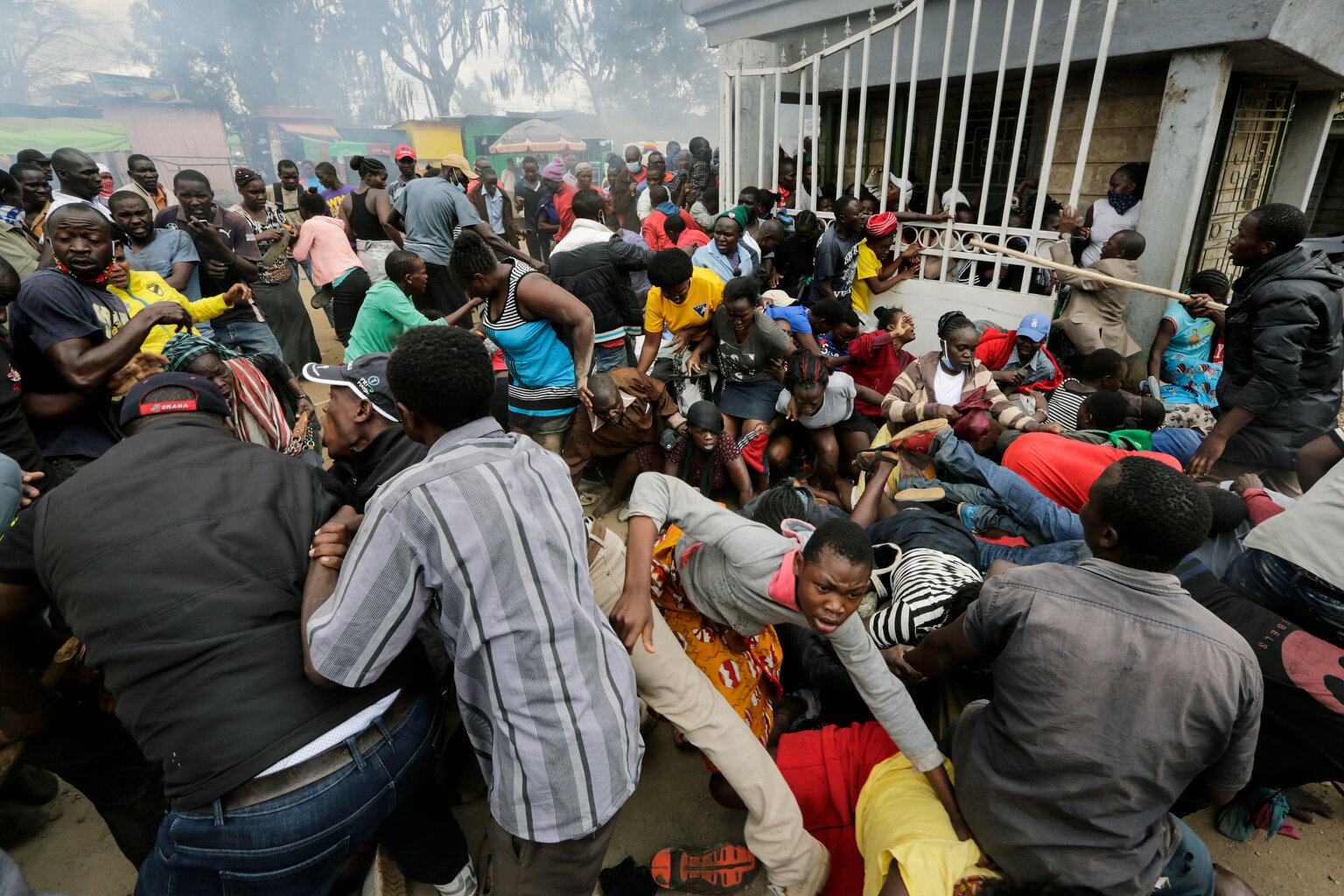  Residents desperate for a planned distribution of food for those suffering under Kenya's coronavirus-related movement restrictions push through a gate and create a stampede, causing police to fire tear gas at a district office in the Kibera slum of 