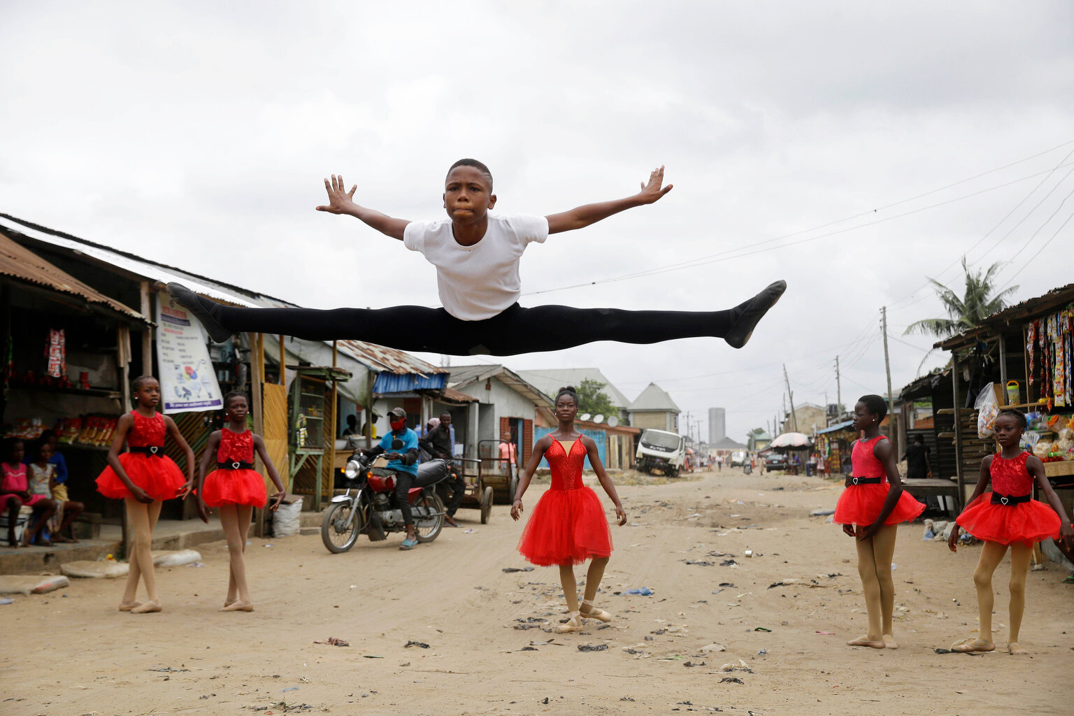  Ballet student Anthony Mmesoma Madu, center, dances in the street as fellow dancers look on in Lagos, Nigeria on Aug. 18, 2020. Cellphone video showing the 11-year-old dancing barefoot in the rain went viral on social media. Madu's practice dance se