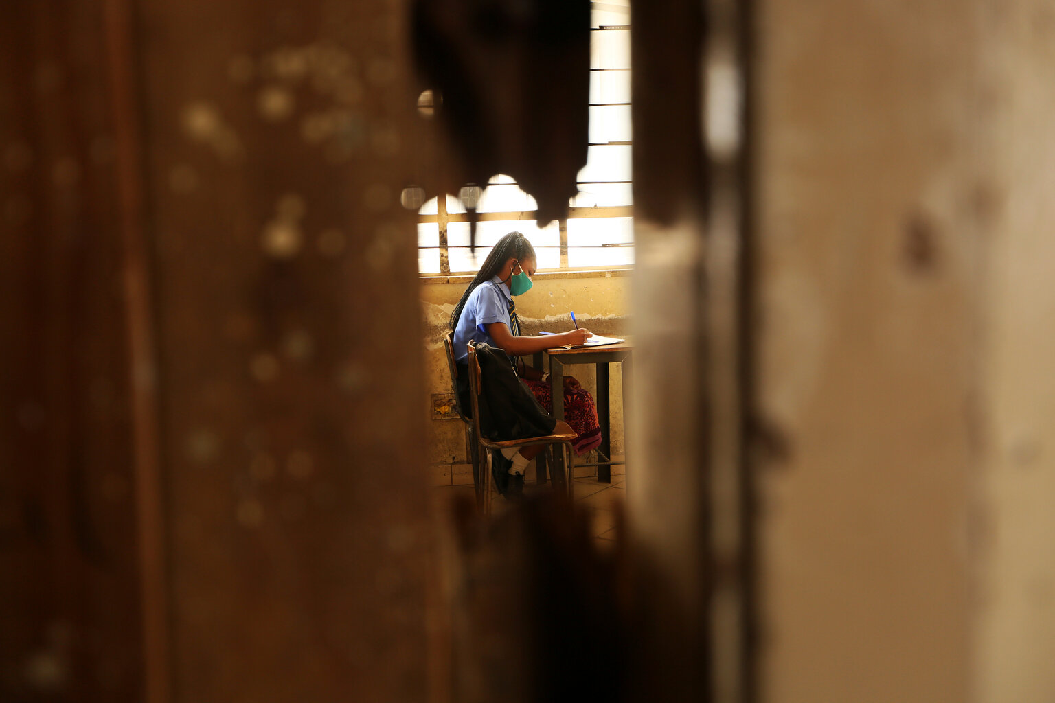  A student takes notes inside a classroom at a school in Harare, Monday, Sept, 28, 2020. Zimbabwe schools have reopened in phases, but with smaller number of pupils,more teachers and other related measures to enable children to resume their education